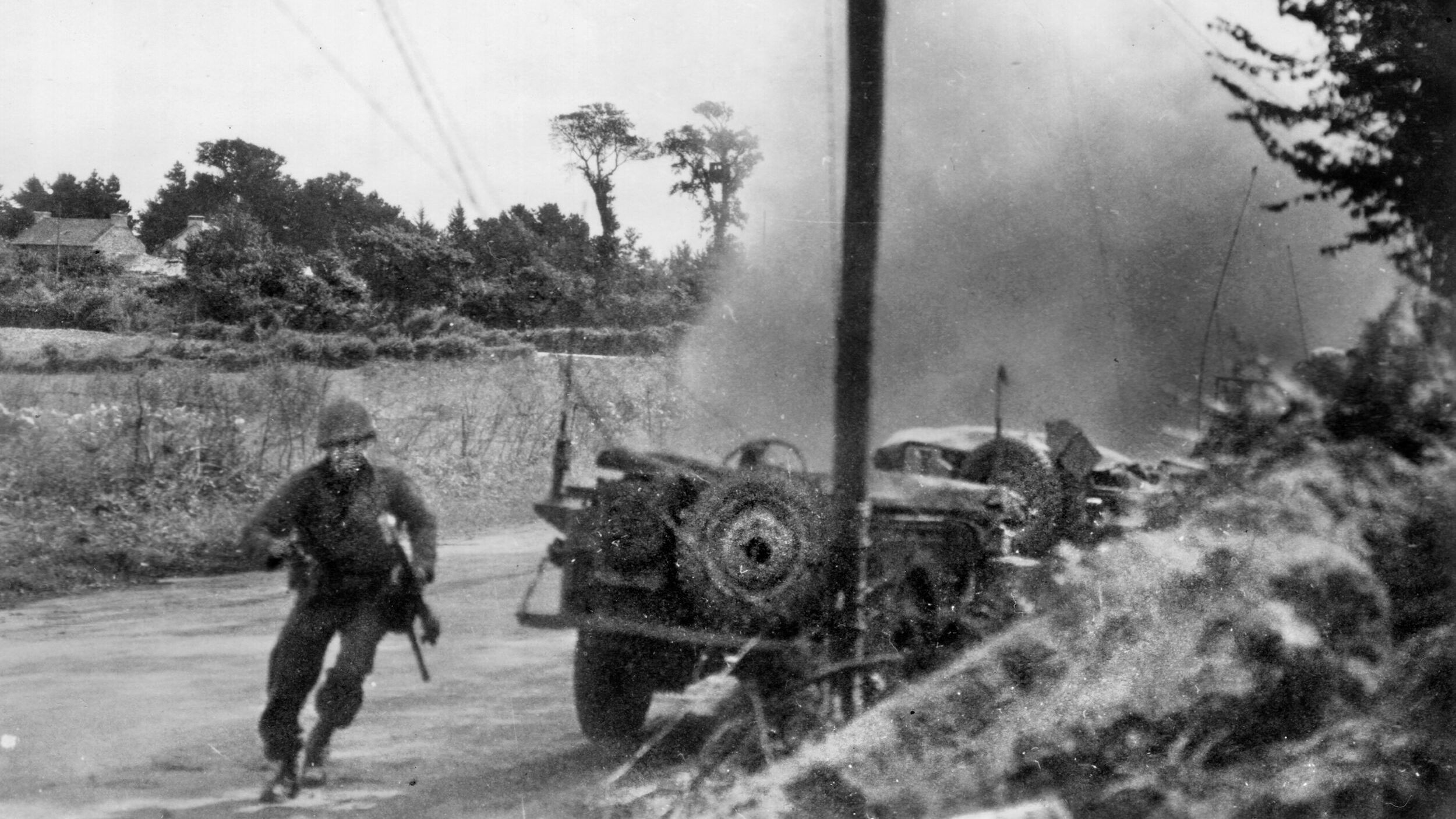 American infantrymen cautiously approach a burning German Tiger I that they have just knocked out of action in the fighting around Mortain. After the battle, the surviving German forces retreated towards Falaise where many would meet destruction.