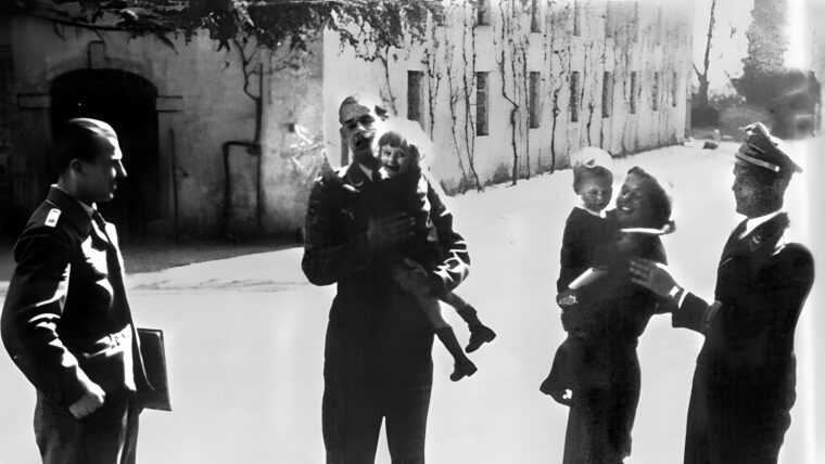 Fey von Hassell smiles faintly for the camera at her estate, Brazza, in the summer of 1944. Fey is accompanied by a pair of German officers, who were apparently assisting with the children in preparation for relocation.
