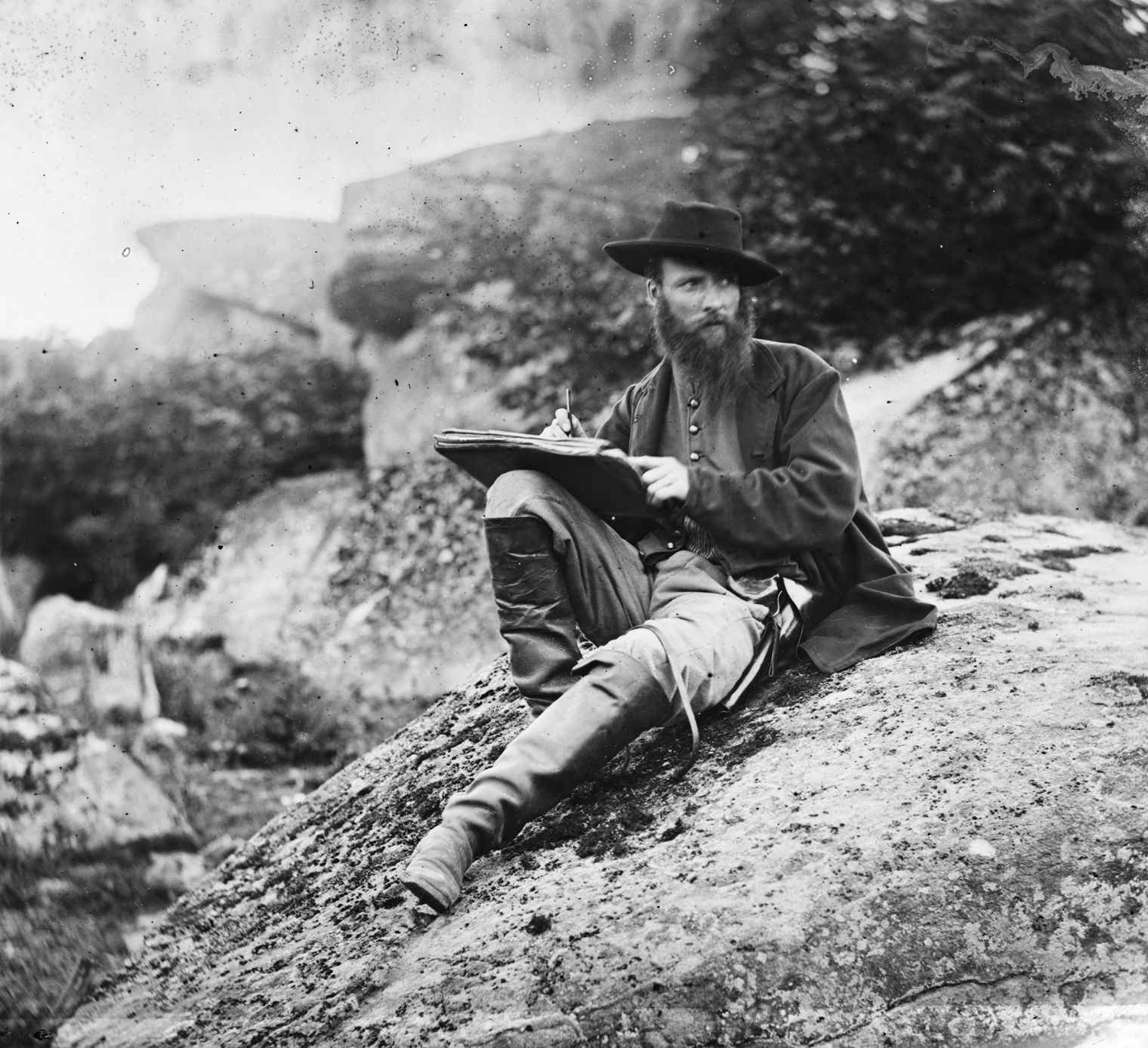 O’Sullivan photographed Harper’s Weekly artist Alfred Waud as he sketched the battlefield from the Devil’s Den.