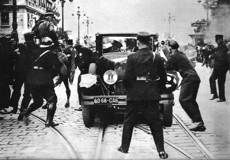 Having fatally shot King Alexander I of Yugoslavia, assassin Vlado Chernozem- ski is struck by a saber- wielding mounted policeman as he clings to the running board of the king’s car.