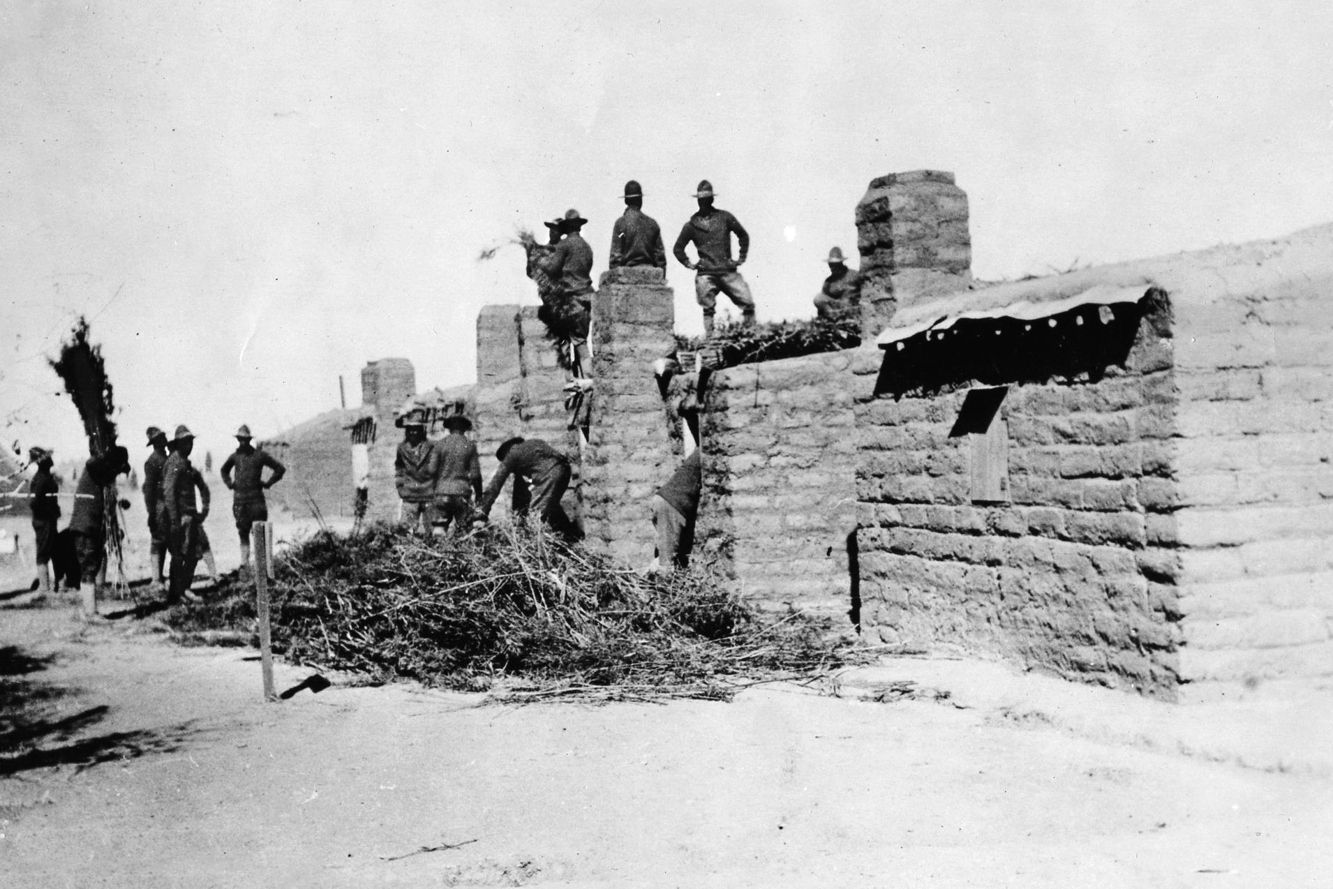 Patton fell through the thatched roof of the Rubio Ranch, much like this one being constructed by U.S. soldiers. 
