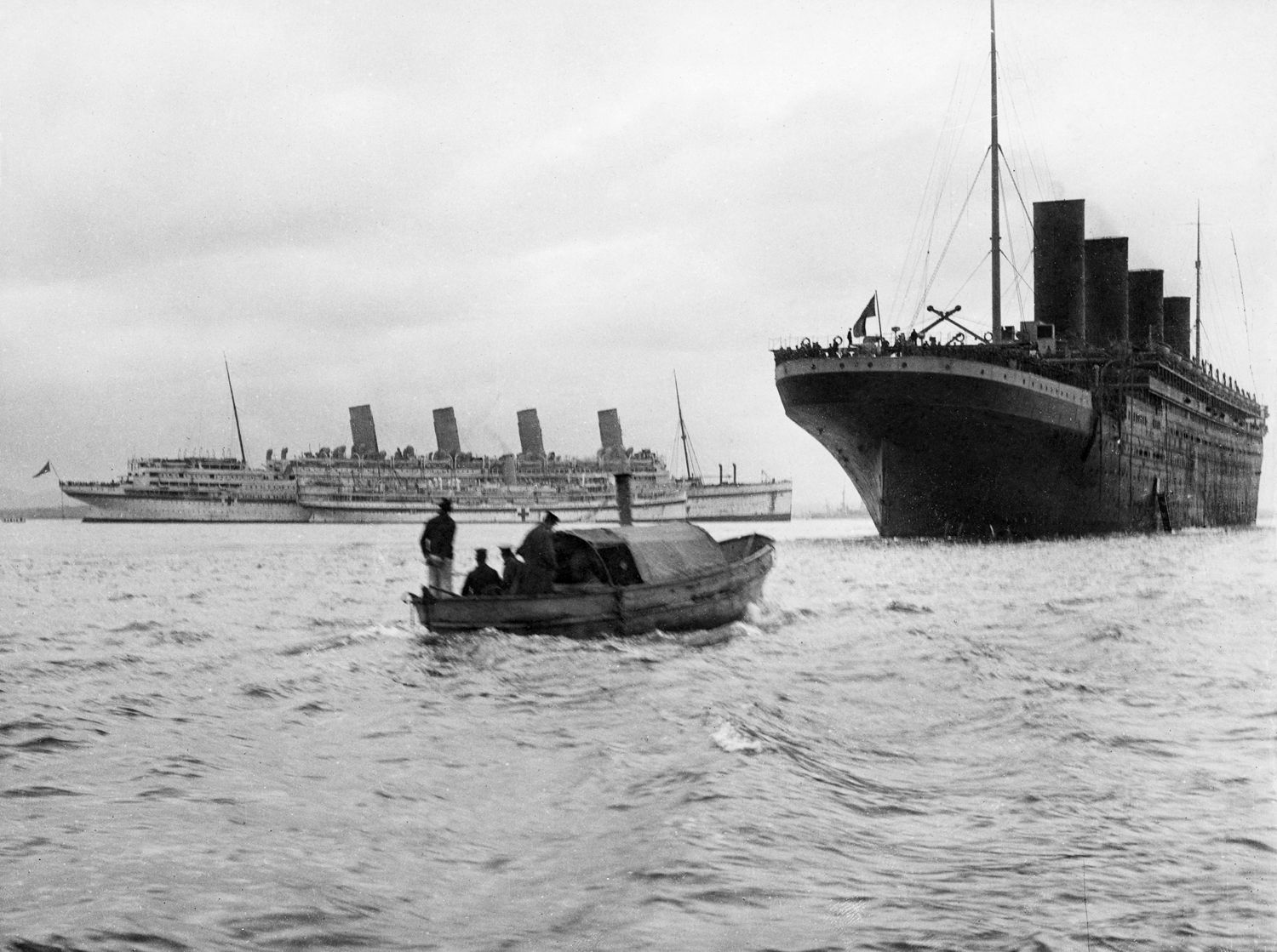 Hospital ship Aquitania, left, and transport Olympic lie at anchor in the Dardanelles in 1915. Aquitania is taking on wounded soldiers for transport to England.