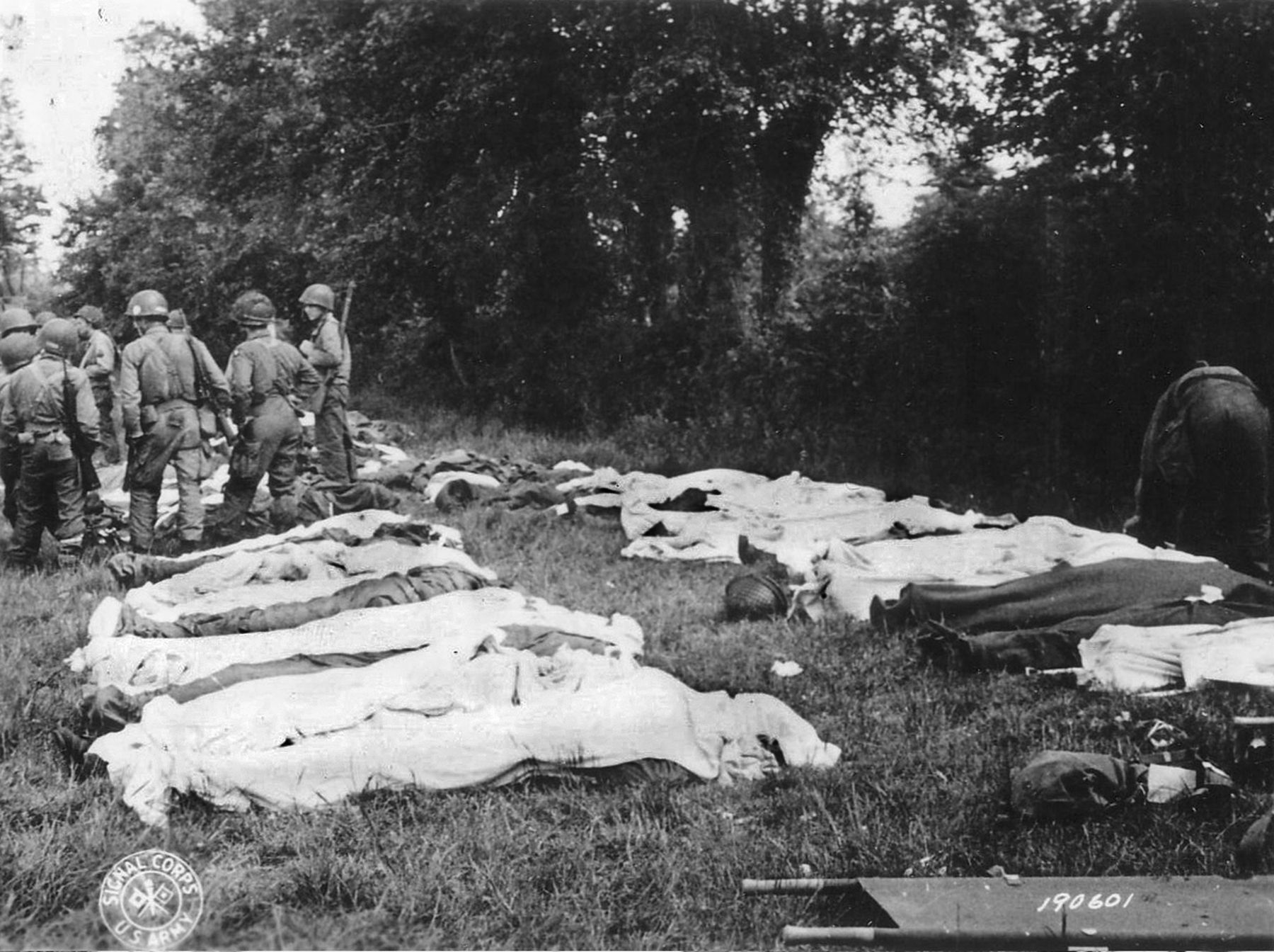 Dead American paratroopers gathered in a field by a Graves Registration unit prior to burial. 