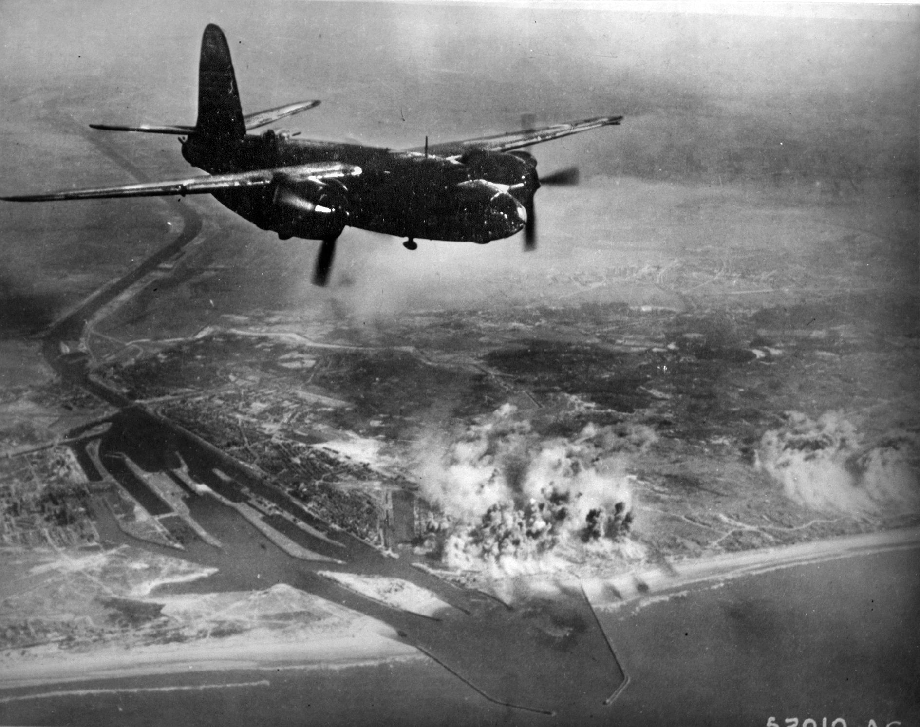 After the failure of the IJmuiden raids, B-26s were used in medium-altitude missions. Here, a B-26 named “Son of Satan” flies above E-boat pens in Holland that have just been bombed.