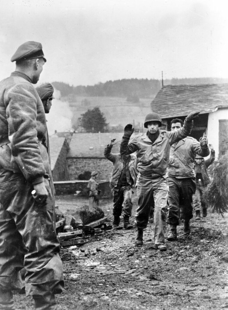 During their Ardennes offensive, German units captured thousands of GIs who thought they were occupying a “quiet” sector of the front. Here, Americans are being rounded up in a village before being evacuated to the rear. 