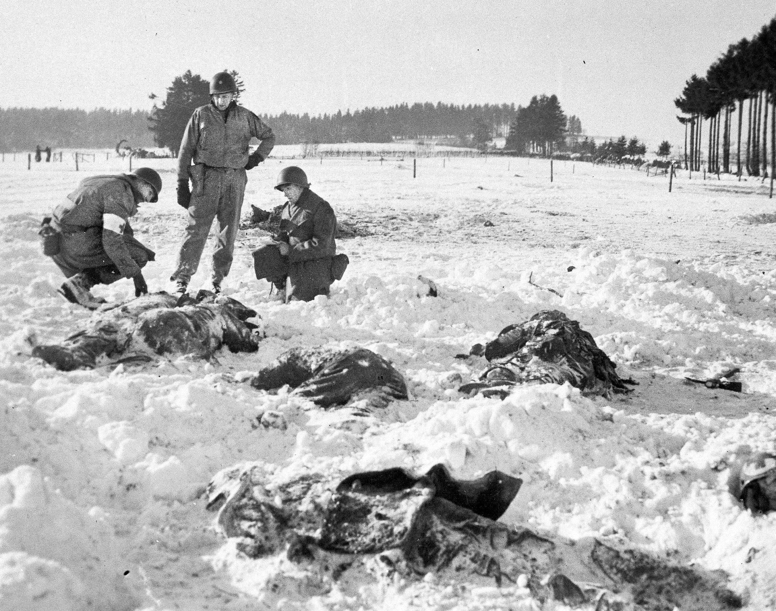 Medical personnel examine the corpses of the slain Americans, many of whom were shot at close range. The exact number killed has never been determined, but the “official” count was at least 86.