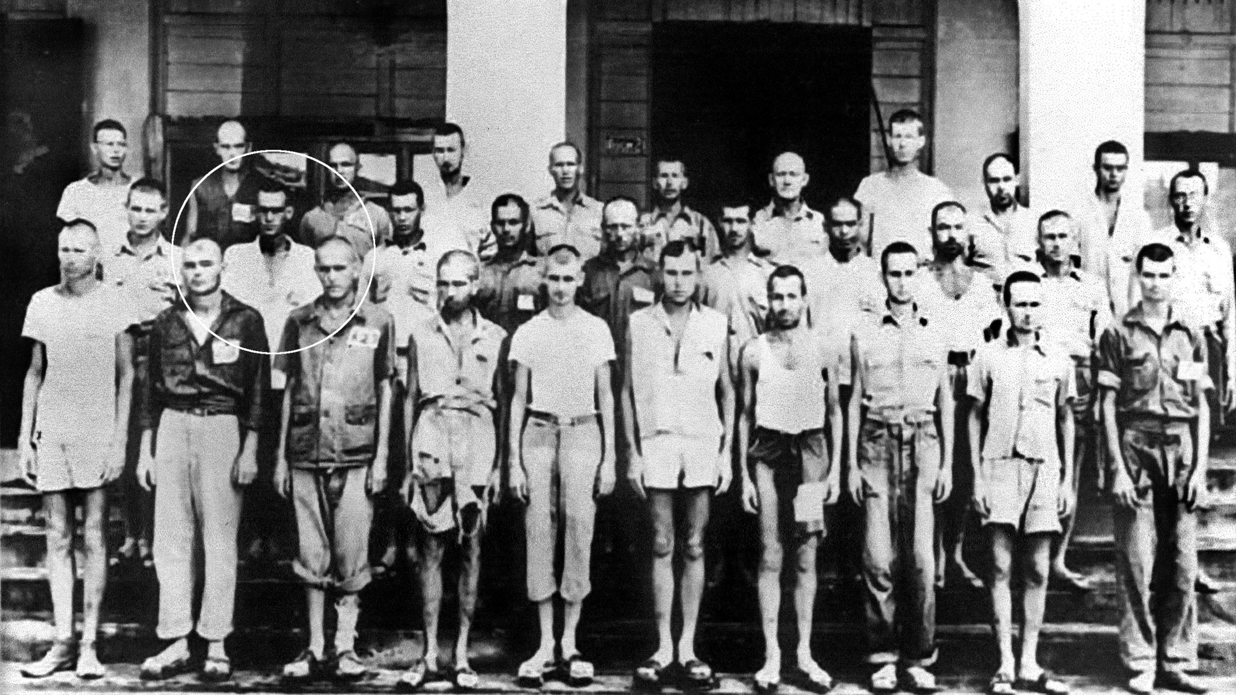 Sickly and malnourished, surviving prisoners of the horrific Nichols Field work detail are shown in front of the Pasay schoolhouse that served as their barracks. Joe, now 17, is second from left in the second row, circled. 