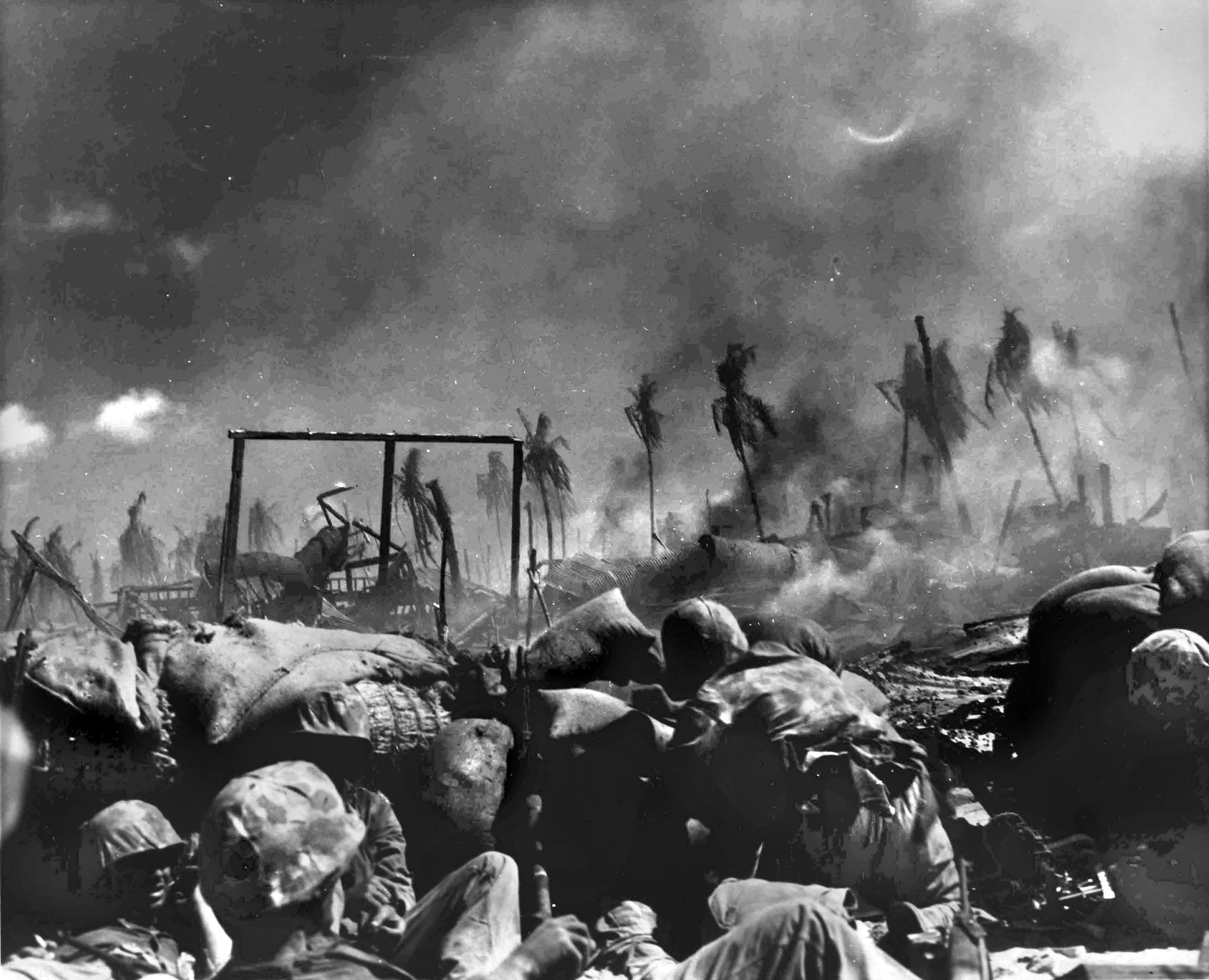 A Marine (center right) tosses a grenade at a Japanese position while his buddies prepare to make contact with the enemy, just a few yards away. 