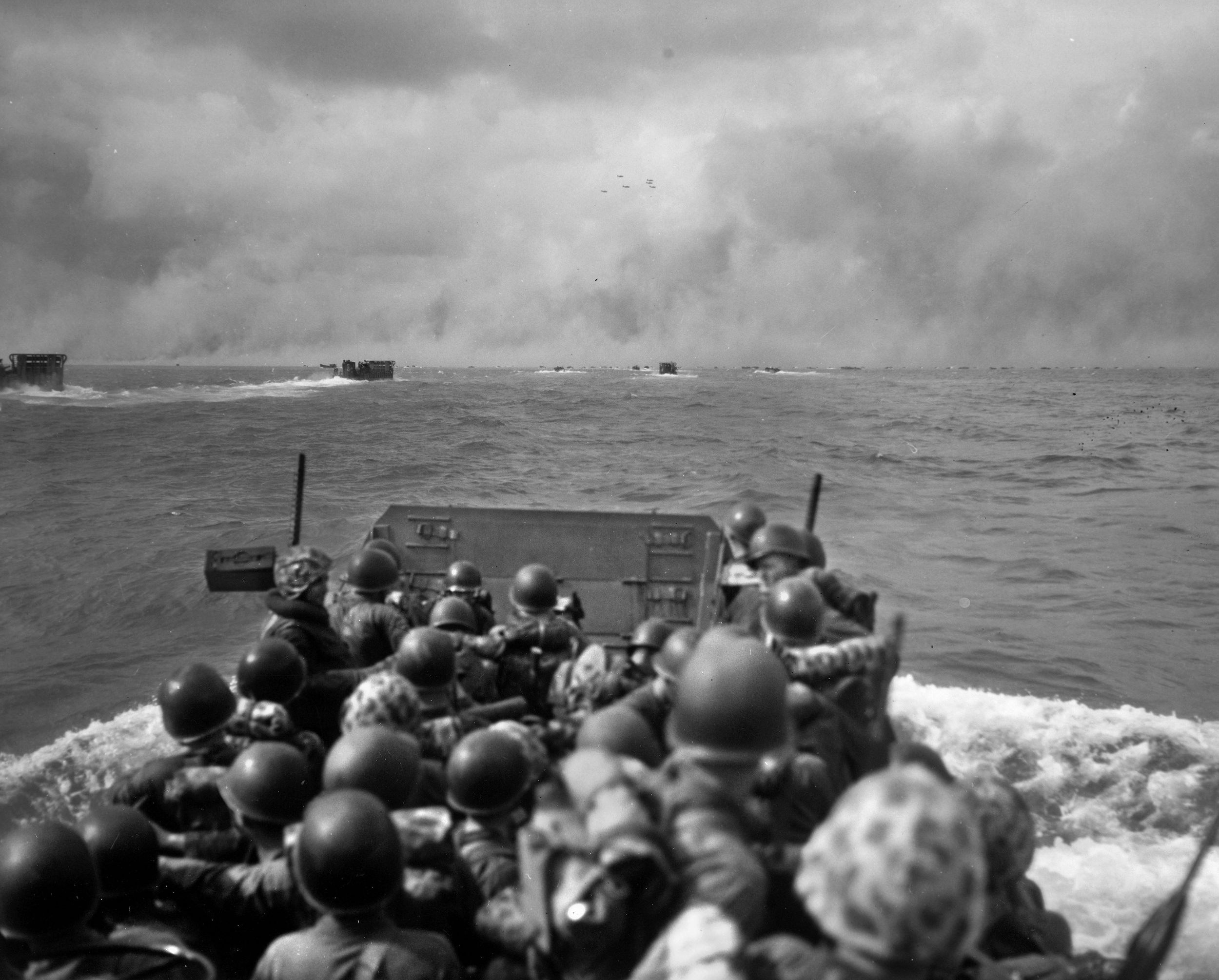 Smoke from the naval bombardment shrouds the Betio shoreline as LCVPs (Landing Craft, Vehicle and Personnel—also known as “Higgins” boats) packed with Marines, head for the invasion beaches. Many Marines were cut down before they even reached the beaches.
