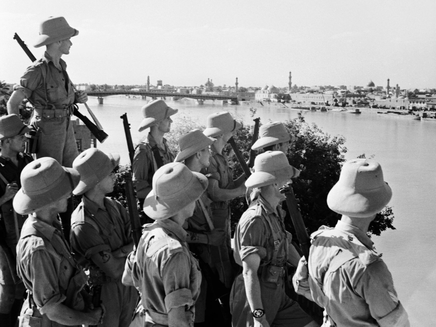Armed with Enfield rifles, British troops view Baghdad from across the Tigris River, June 1941.
