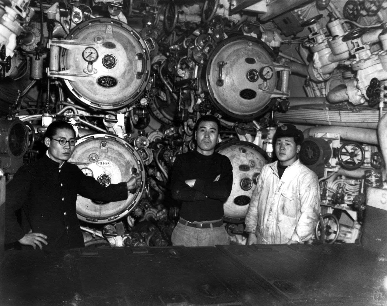This view of the forward torpedo room of the Japanese submarine I-58 shows three crewmen with a 21-inch torpedo tube. The photo was taken in Sasebo, Japan, in 1946. 