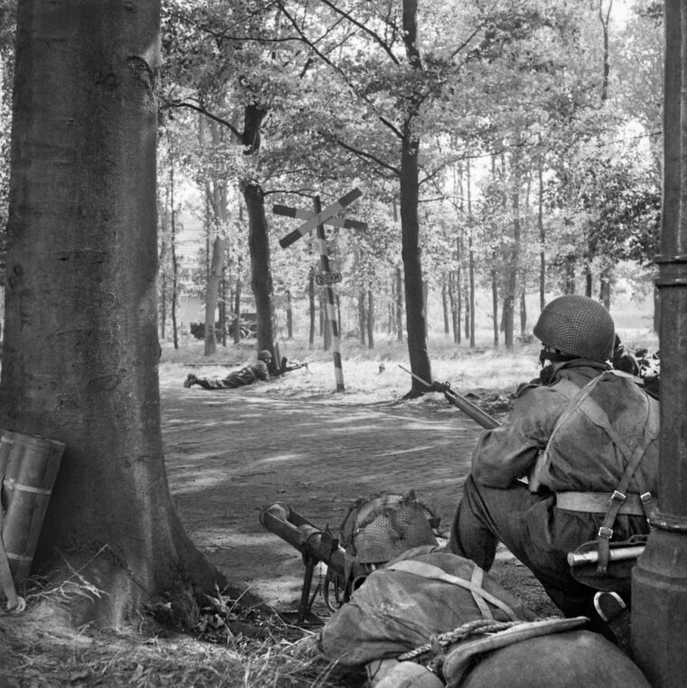  On September 18, 1944, British airborne soldiers of C Troop, 1st Airlanding Reconnaissance Squadron, aim a PIAT antitank weapon toward the Germans as they cover a road near the Dutch town of Wolfheze.