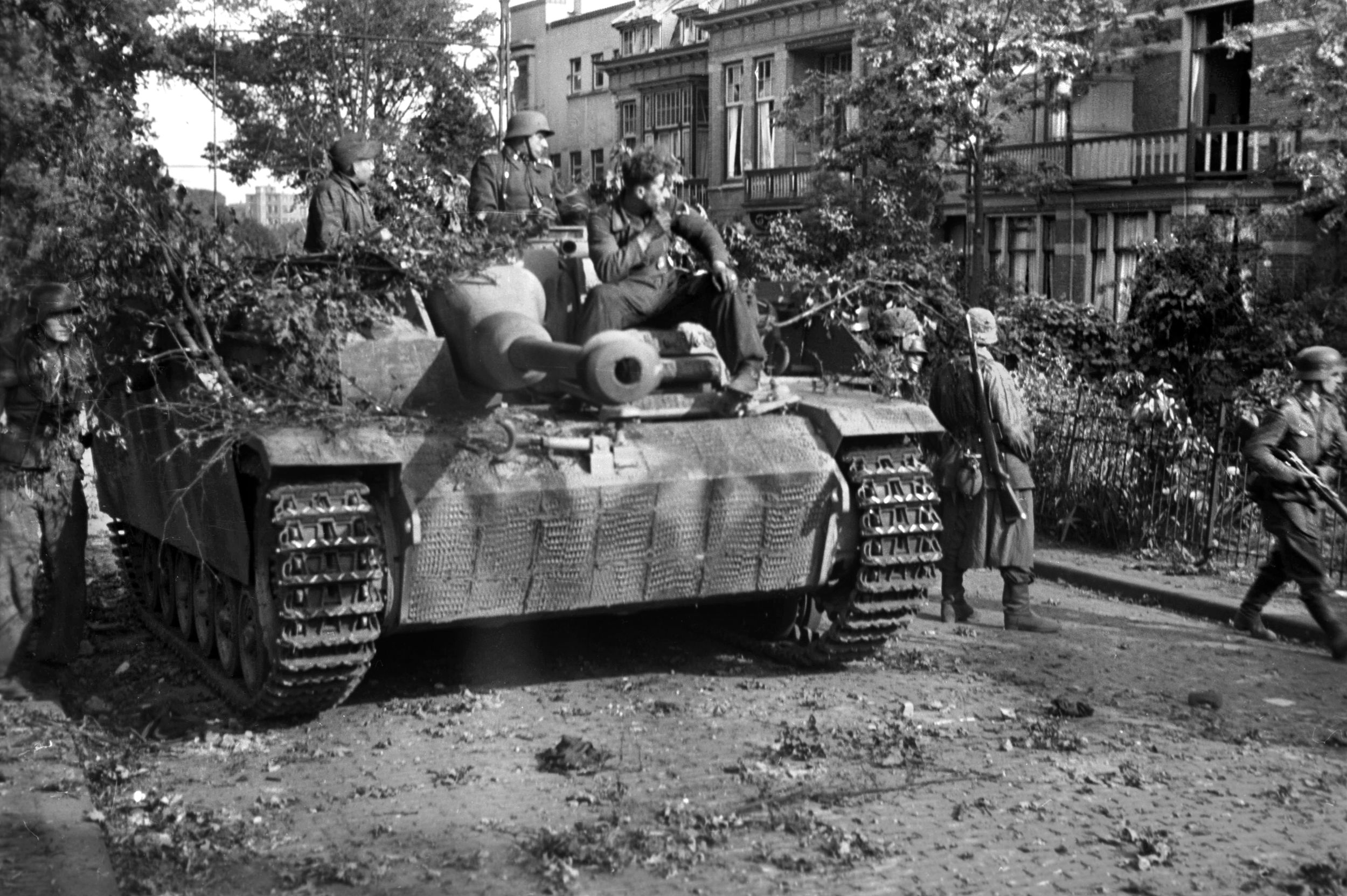 German soldiers sit atop a Sturmgeschutz III self-propelled assault gun in a Dutch town while other troops sweep the area. These armored vehicles were among those that British commanders did not believe constituted a threat to Operation Market-Garden.