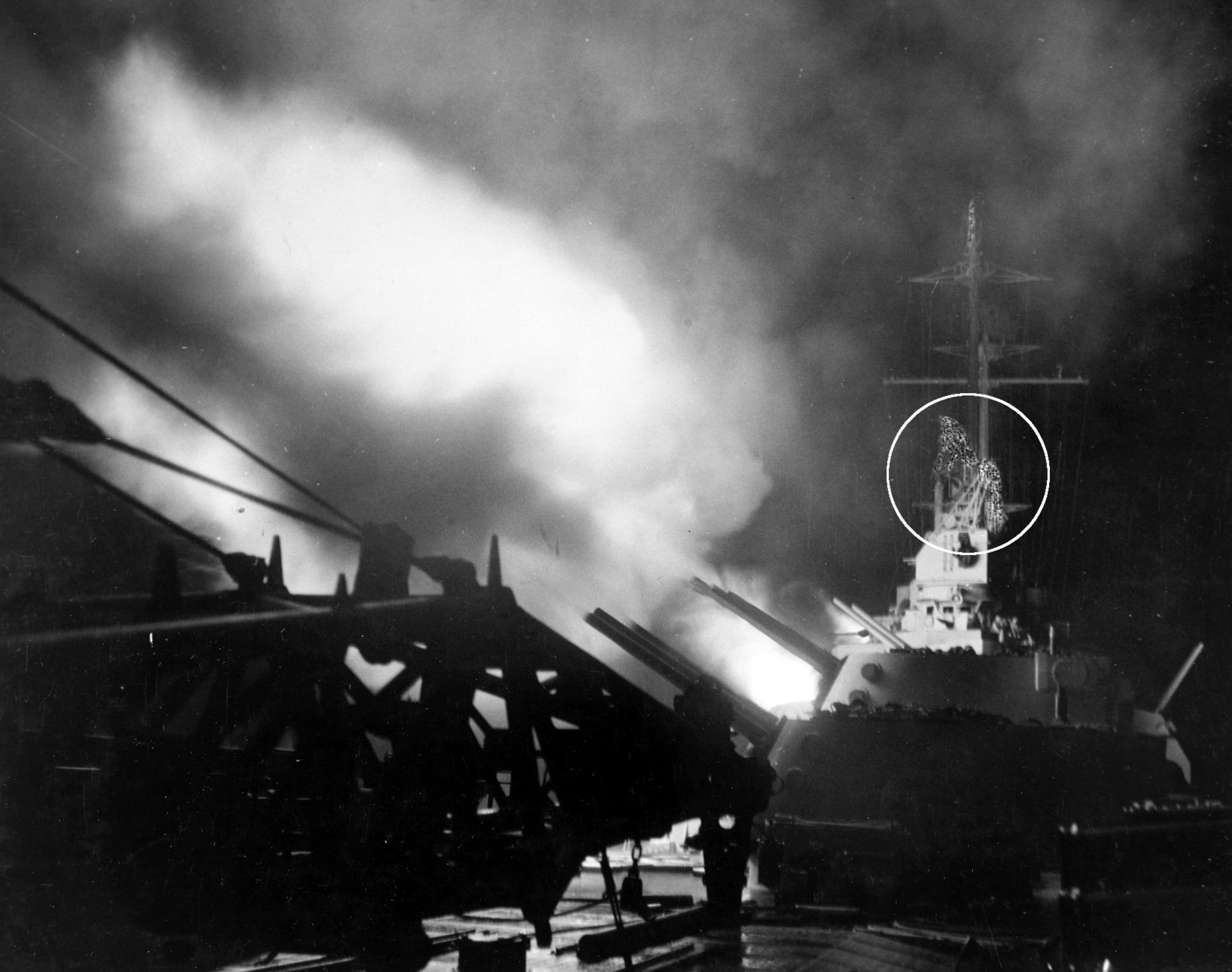 The aft 6-inch guns of the light cruiser USS Columbia fire at Japanese positions in the Shortland Islands, supporting the American landings on the island of Bougainville, November 1, 1943. A censor has crudely painted over the cruiser’s radar apparatus (circled).