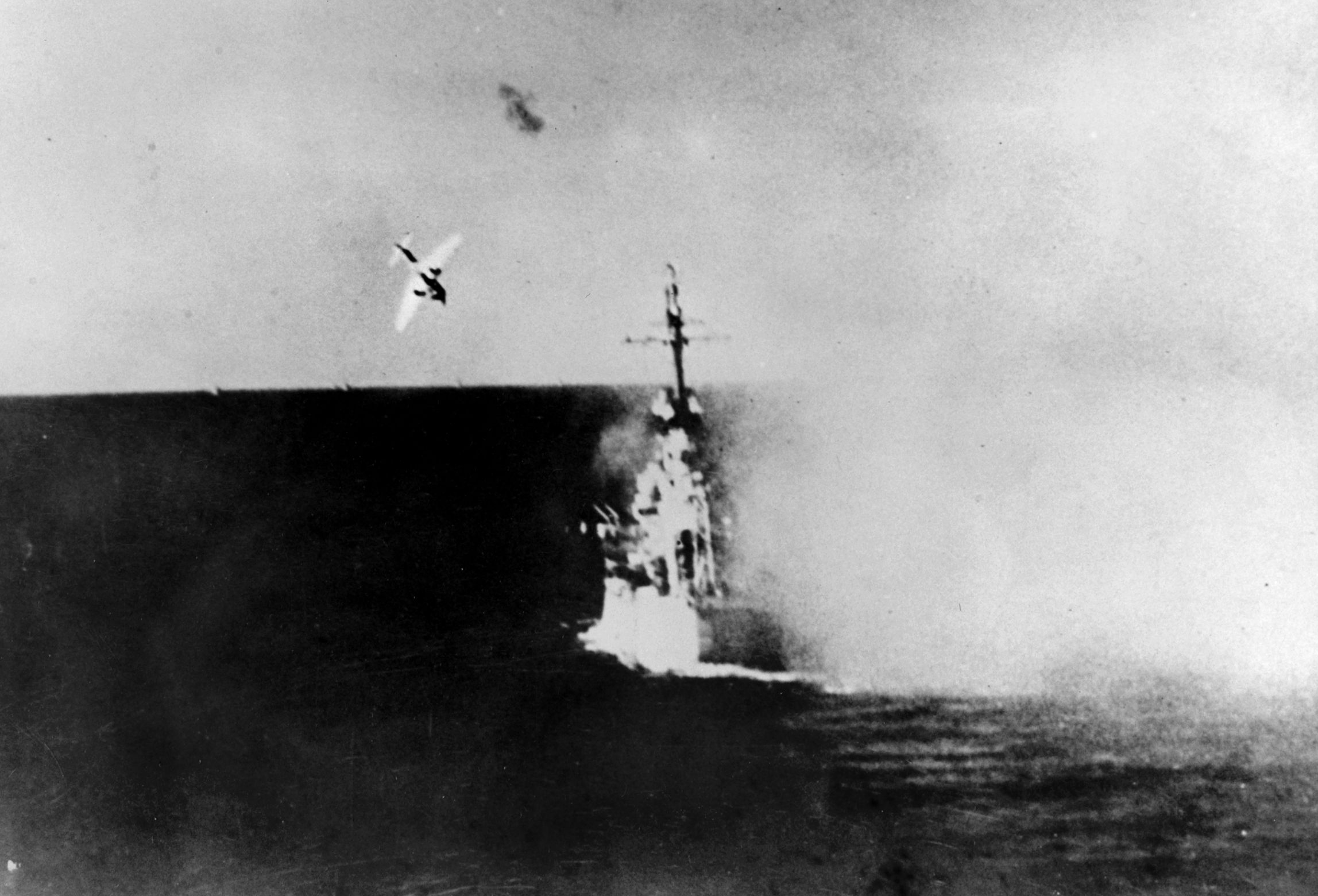 A Japanese kamikaze suicide plane dives on the light cruiser USS Columbia on January 6,  1945. The enemy plane crashed into the cruiser near the aft guns causing extensive damage and killing a number of crewmen during this action in Lingayen Gulf.