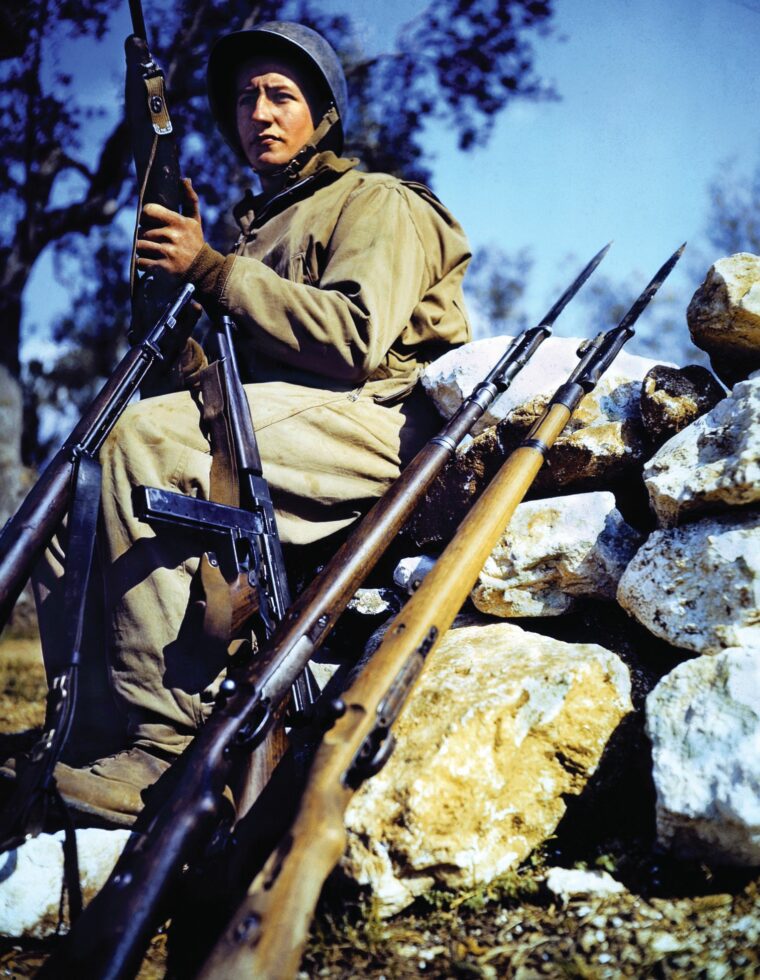 Corporal Charles “Commando” Kelly poses with several different types of weapons during the Italian Campaign in this U.S. Army publicity photo. 
