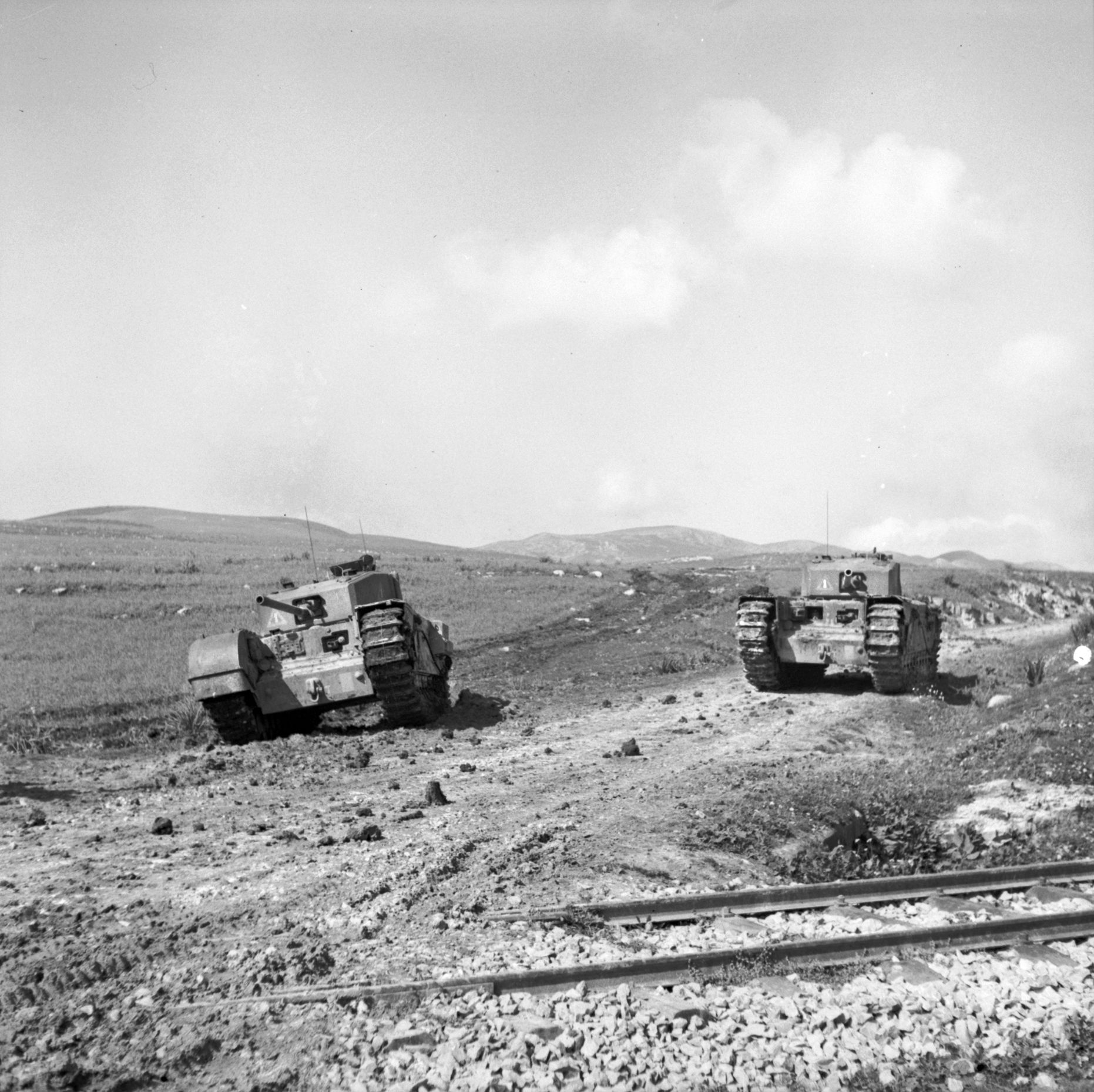 Two British Churchill tanks move along the desert floor the day of the fight at Steamroller Farm. When Hollands and Lieutenant J.G. Renton managed to return to friendly lines, their fellow soldiers did not believe the amount of destruction they caused the Germans. When the battlefield was inspected days later, the damage was even greater than the two officers reported. 