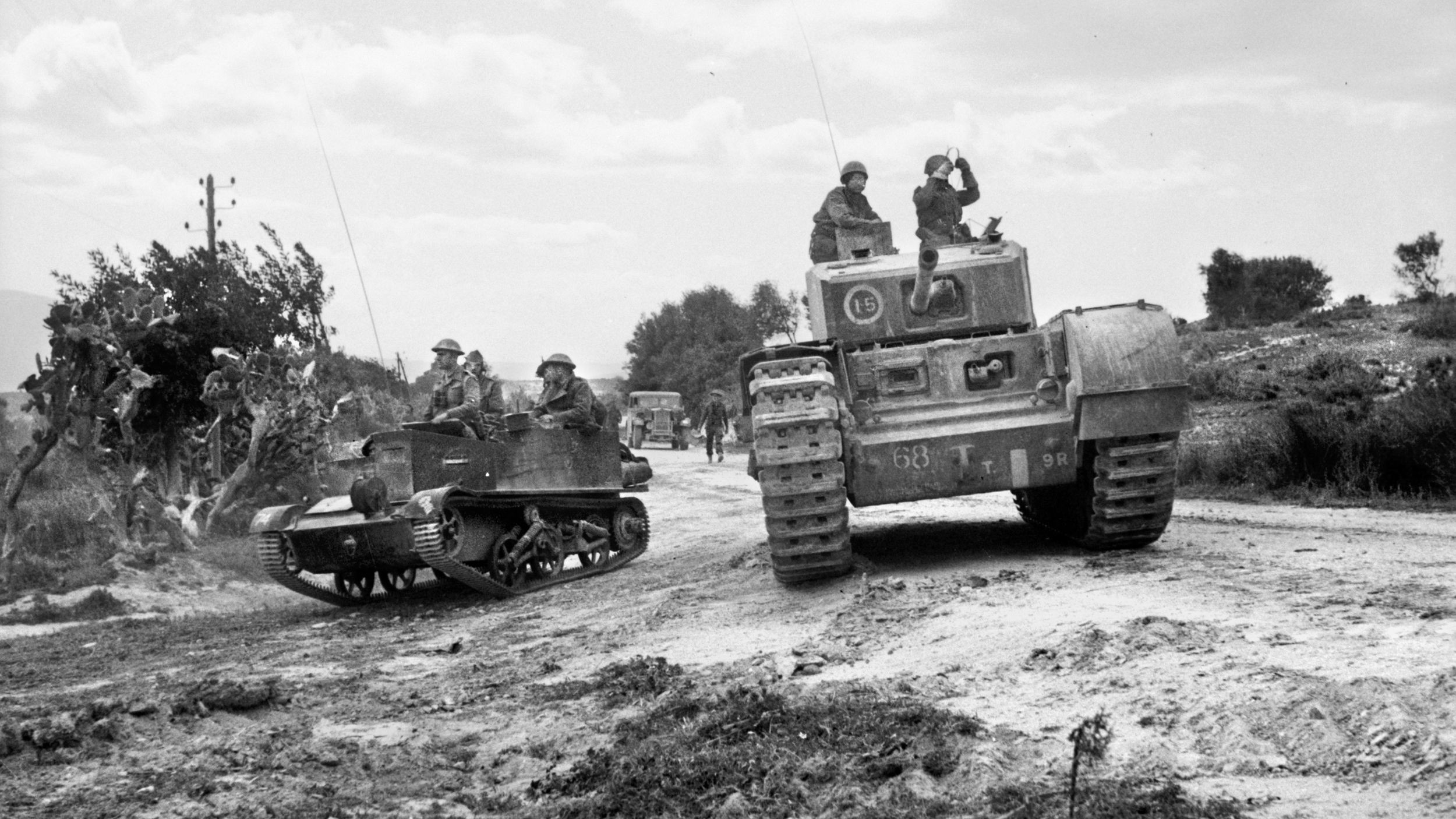 British soldiers in a universal carrier and a Churchill tank are seen moving forward in Tunisia in 1943. These soldiers are with the 51st Royal Tank Regiment. 