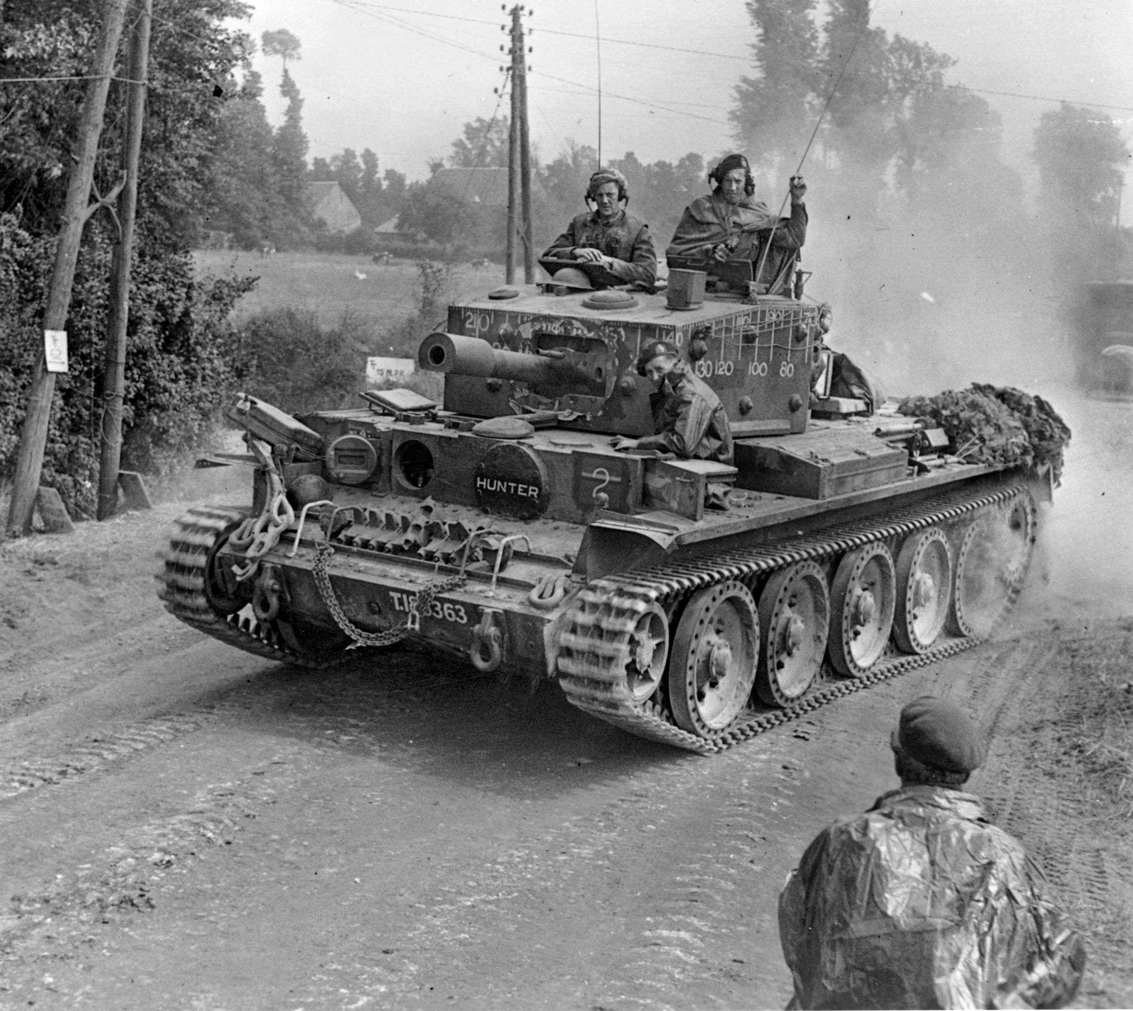 During the British advance of July 13, 1944, near Tilly-sur-Seules, a British Cromwell tank stirs up a cloud of dust.