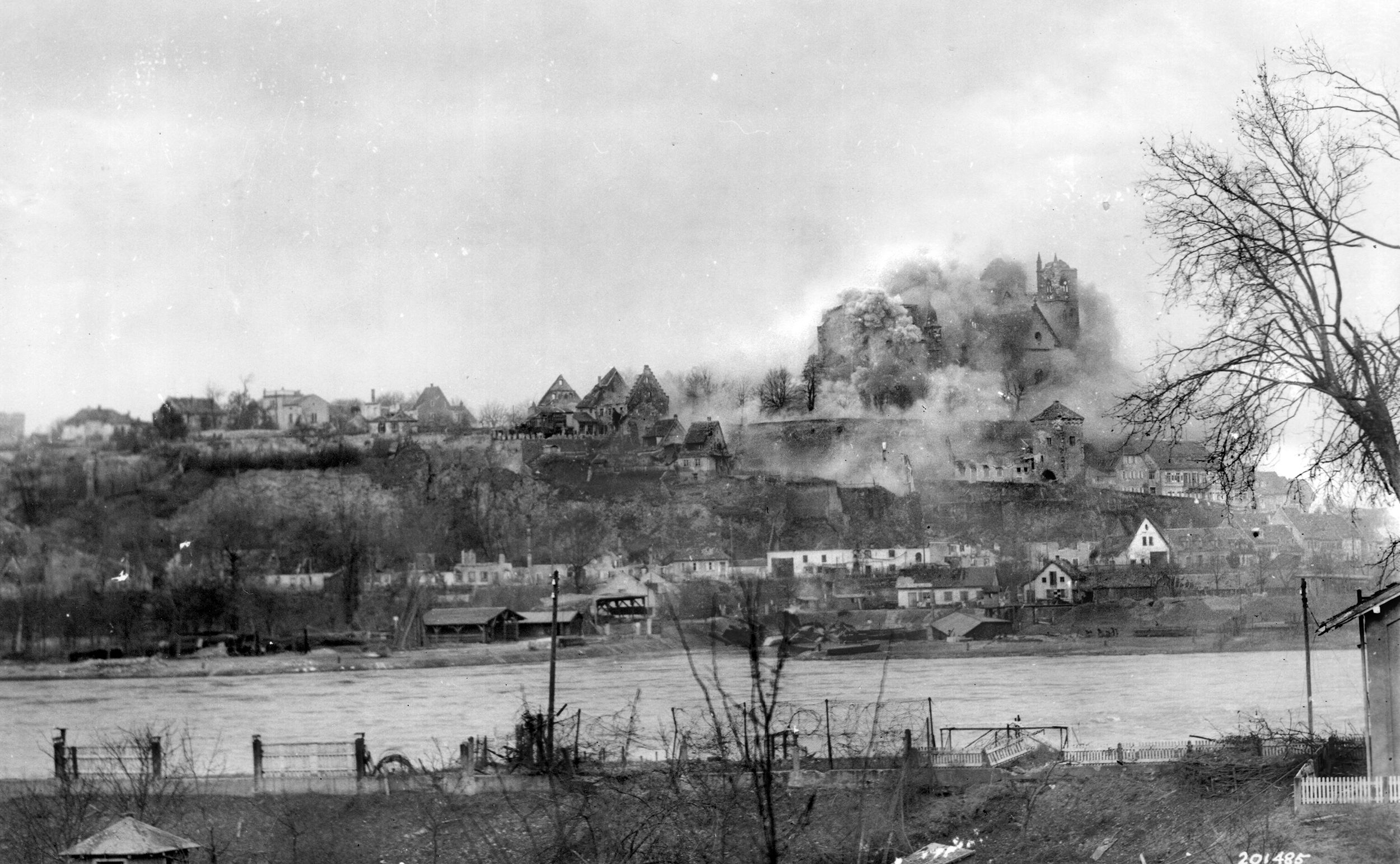 The U.S. 30th Infantry Regiment fires on German targets with its 155mm howitzers at Neuf Breisach on the Rhine River.
