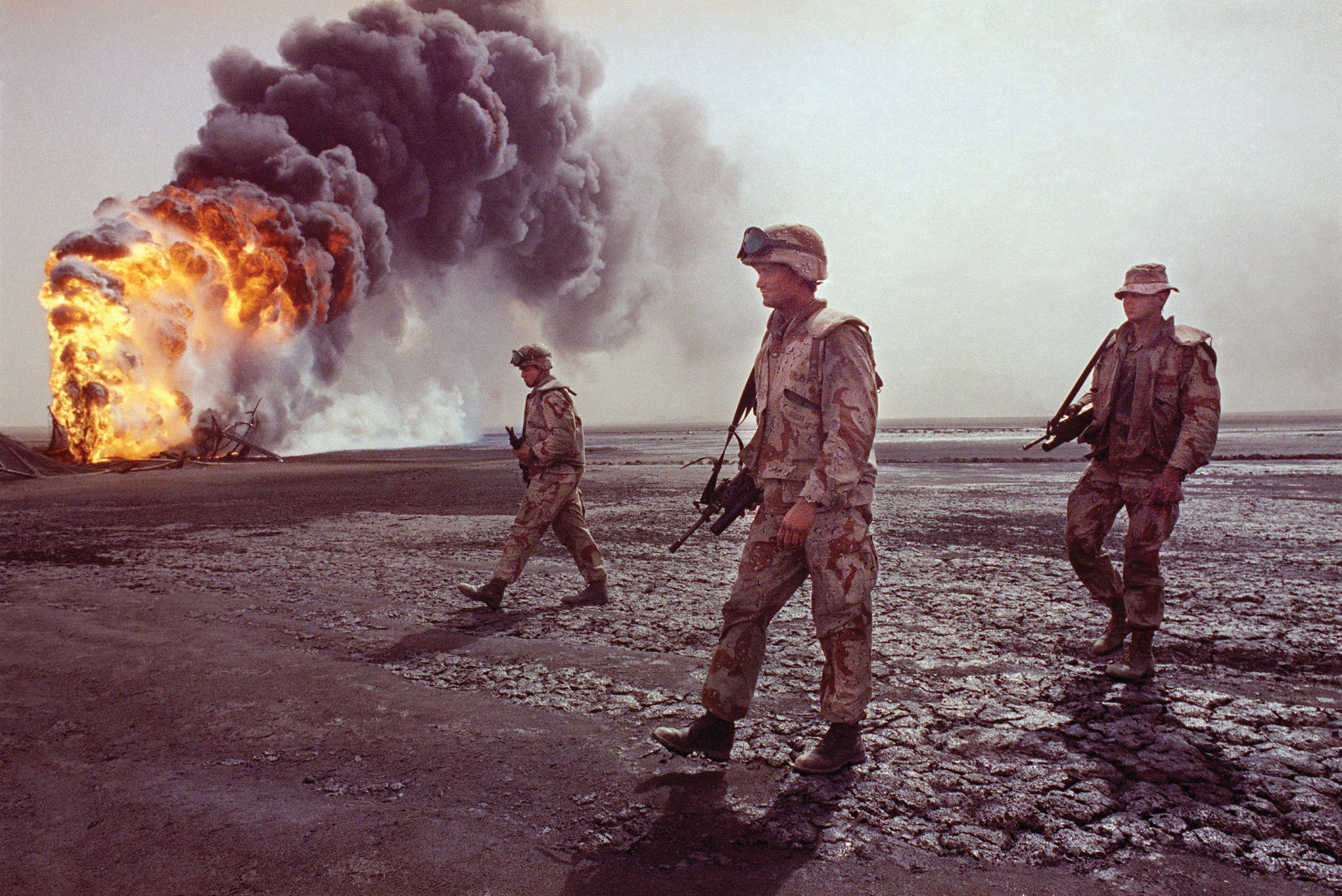 U.S. Marines walk through a desert landscape charred by burning oil fires. U.S. forces benefitted in the Gulf War from sophisticated technologies, including night-vision goggles for soldiers and Marines, forward-looking infrared pods for aircraft, and thermal and optical gun sights for tank crews. 