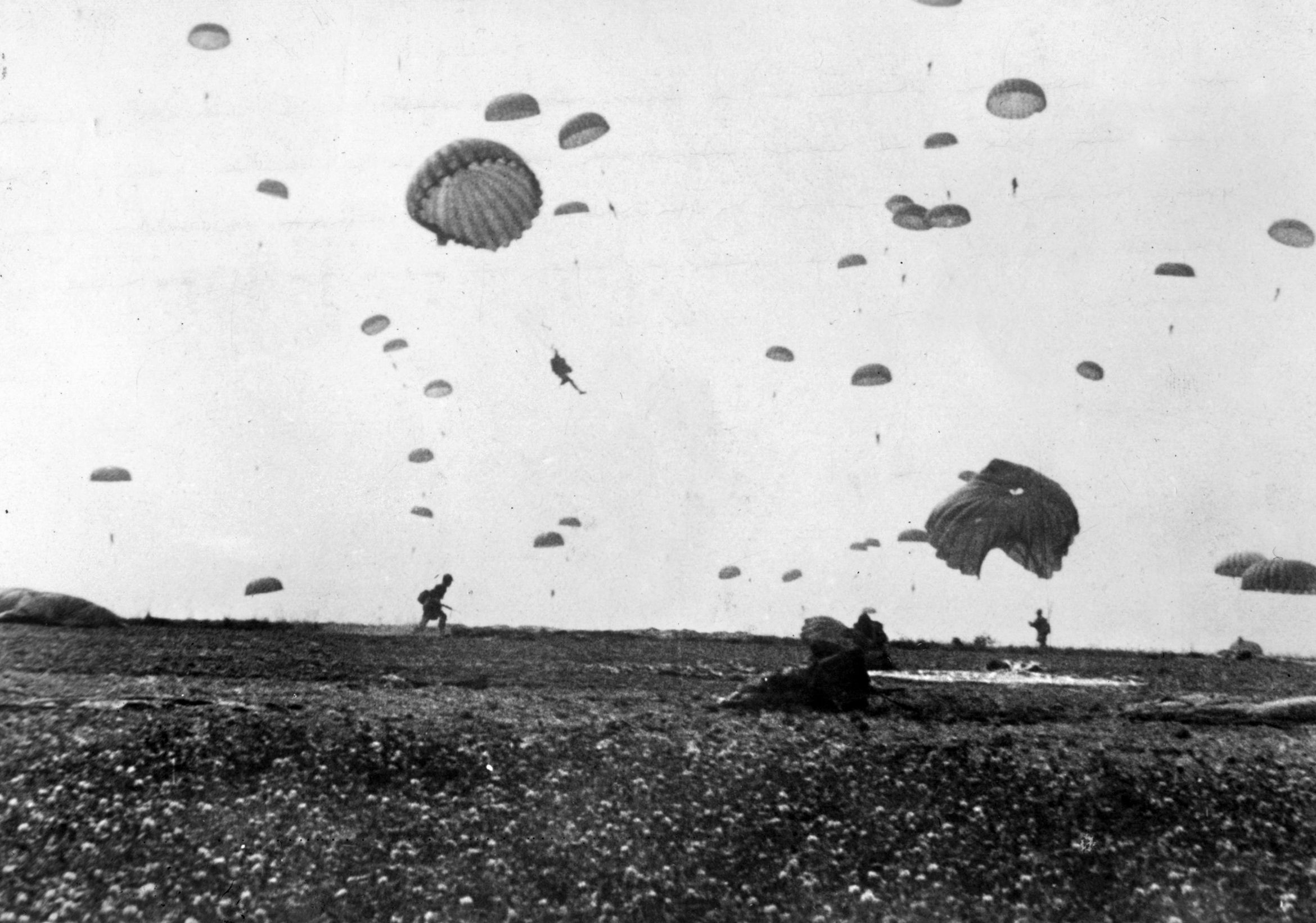 The sky of Holland is filled with American paratroopers while others are already out of their harnesses and running off the drop zone toward their assembly areas. 