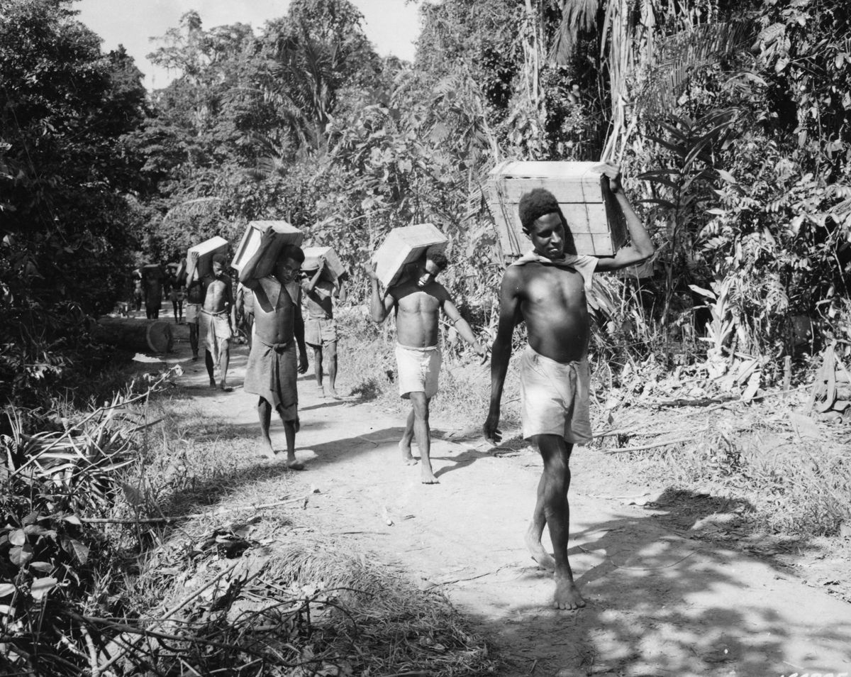 New Guinea natives carry ammunition and supplies to the front lines, December 25, 1942. 