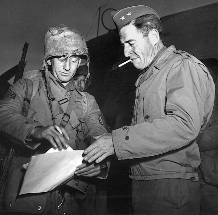 Major General E.F. Harding (left), commander of the U.S. 32nd Division, chats with a member of the 128th Infantry Regiment before departing for a combat area.
