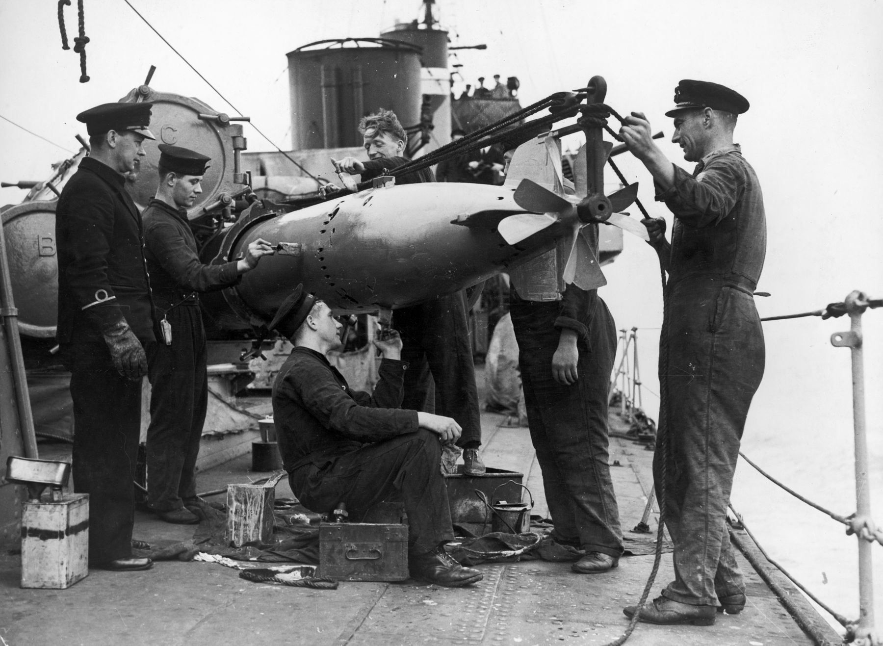 Seamen aboard a Royal Navy destroyer prep a torpedo for a launch against German U-boats, August 1941.
