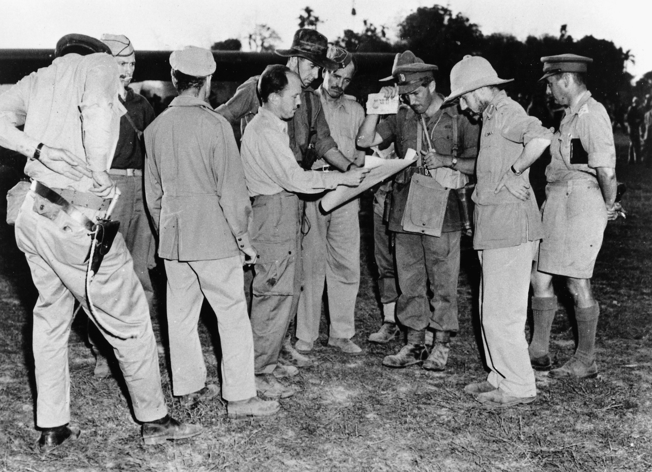 Calvert (touching the visor of his cap) and Brigadier Orde Wingate, commander of the 3rd Indian Division (second from right, in pith helmet), brief their staff officers on Operation Thursday before take-off from the main base at Sylhet, Assam, then part of India.