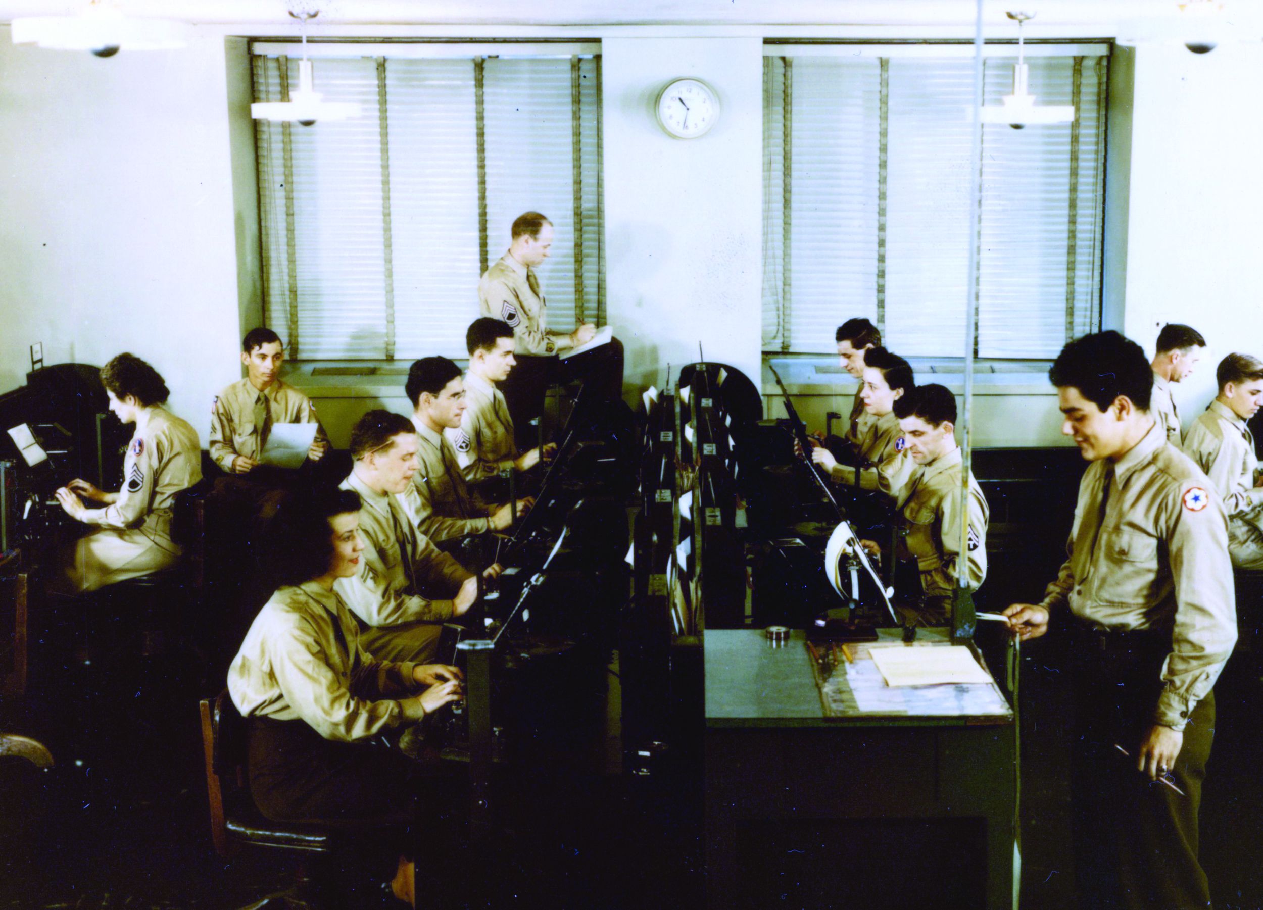 At the Pentagon Signal Center’s message perforating section, communications were received via a belt carrier, perforated, and then passed along through a tube system before transmission. Those who handled messages received varying levels of security clearance.