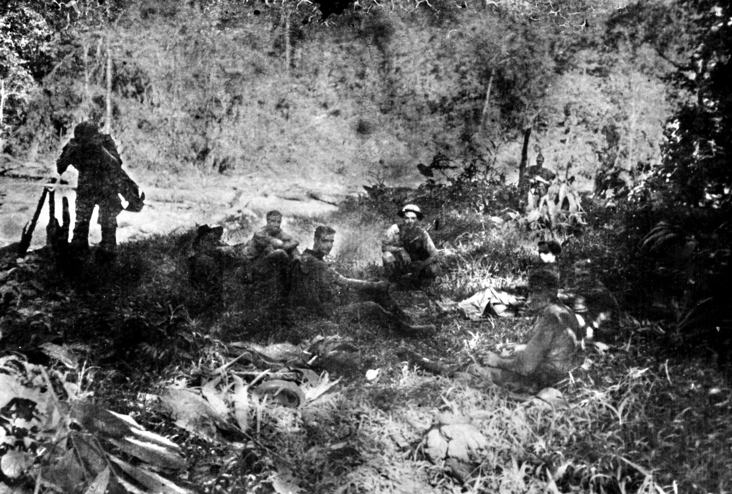 Retreating from the strong Japanese forces that landed near Rabaul on January 23, 1942, these soldiers rest briefly along a primitive trail in New Britain’s Bainings Mountains.  