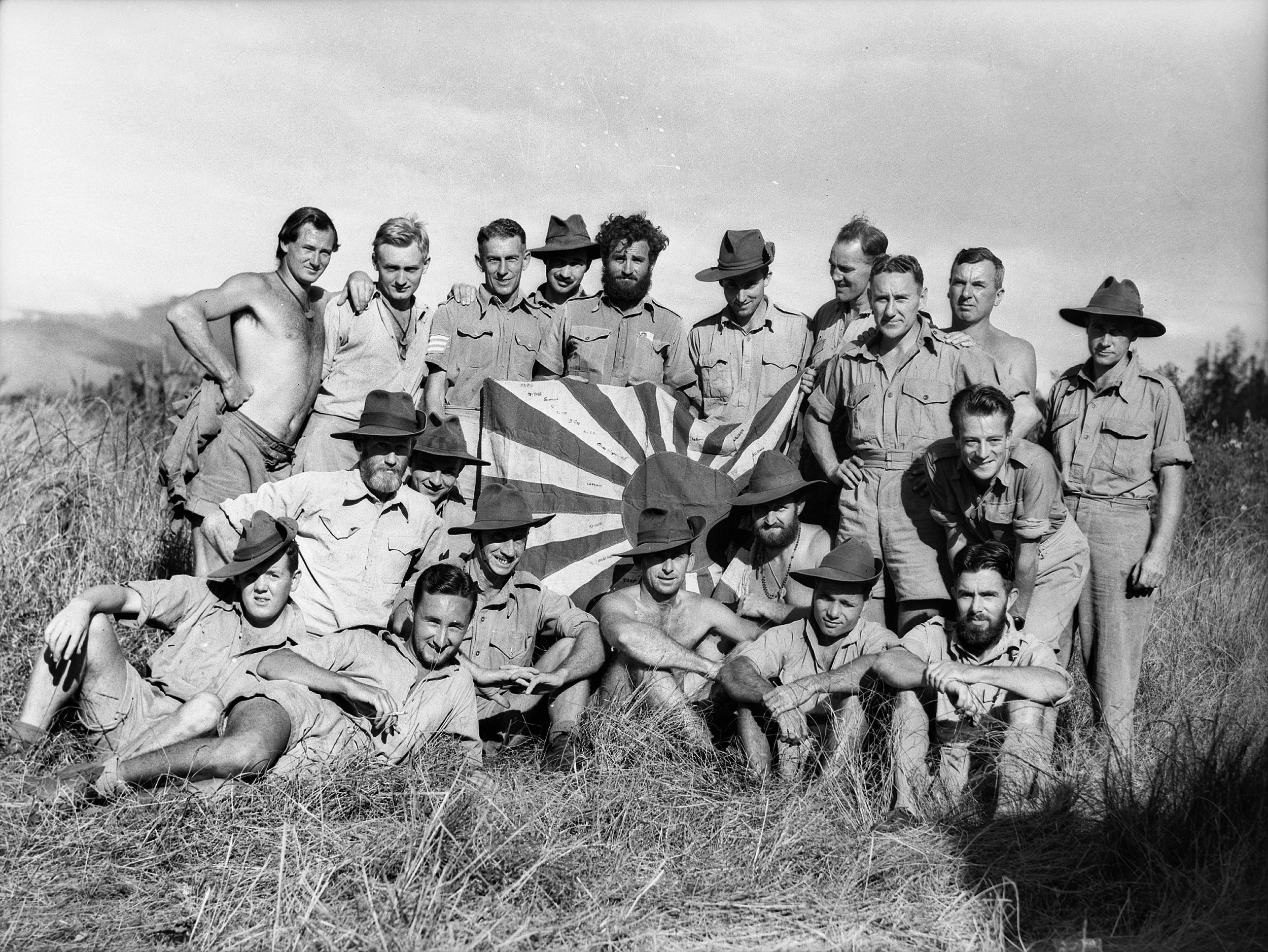 Troops of B Company of the New Guinea Volunteer Rifles stand proudly with a Japanese flag they have captured in battle at Mubo on July 21, 1942.