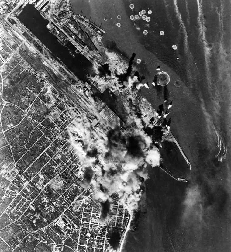 Smoke billows from bomb strikes against the submarine pens at St. Nazaire. This photo was taken from a U.S. bomber that participated in a costly raid against the heavily defended pens on the French coast. 