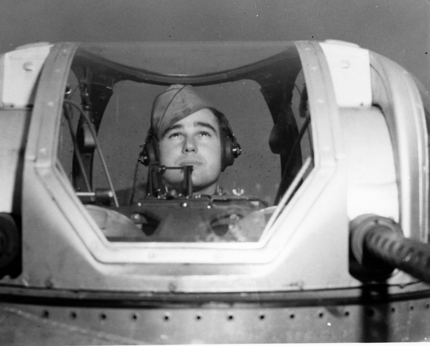 Looking over the barrels of his twin .50-caliber machine guns, Sergeant Arnold Burton sits in the top turret of his B-17. Burton was a participant in several of the early U.S. daylight raids over Nazi-occupied Europe and considered the submarine pens at St. Nazaire his toughest target.