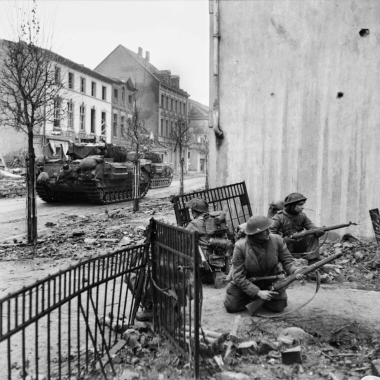 Wary British troops of the 2nd Gordon Highlanders scan windows for German snipers in the town of Kleve.  
