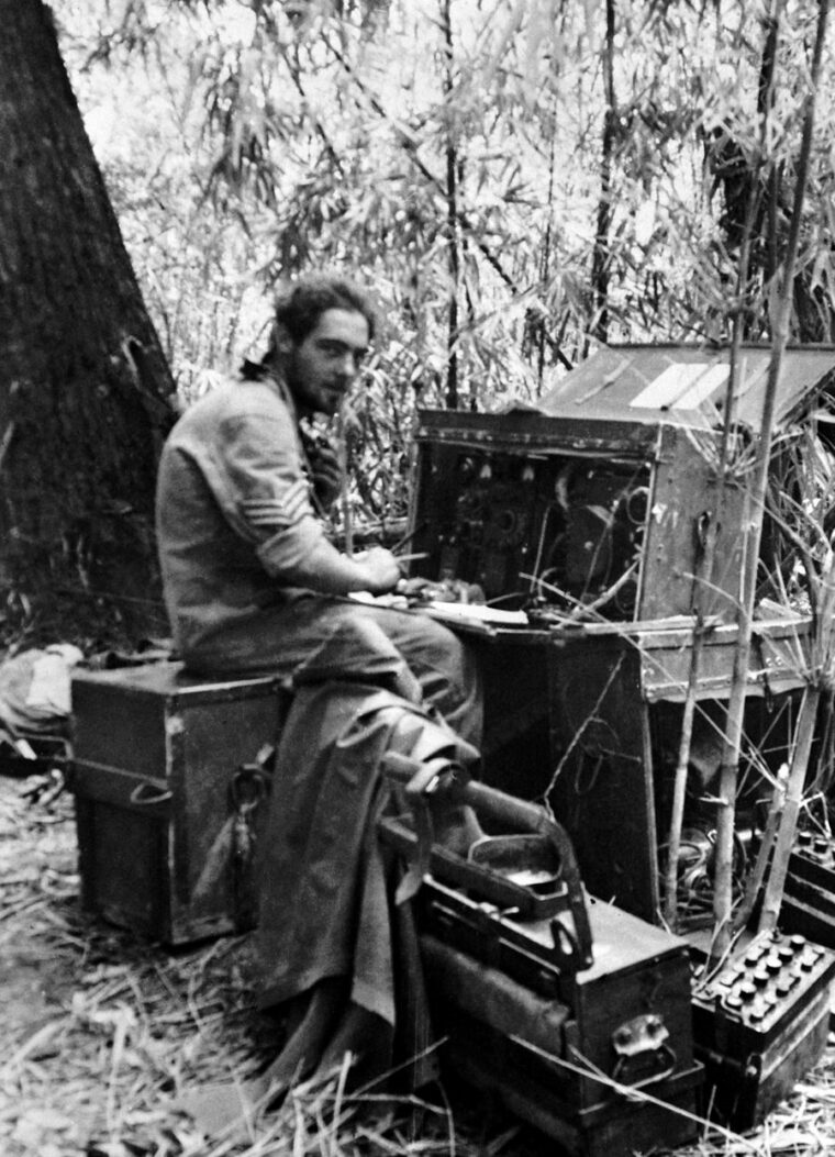 An RAF wireless operator attached to a Chindit column sits with his equipment in a jungle clearing in Burma. 