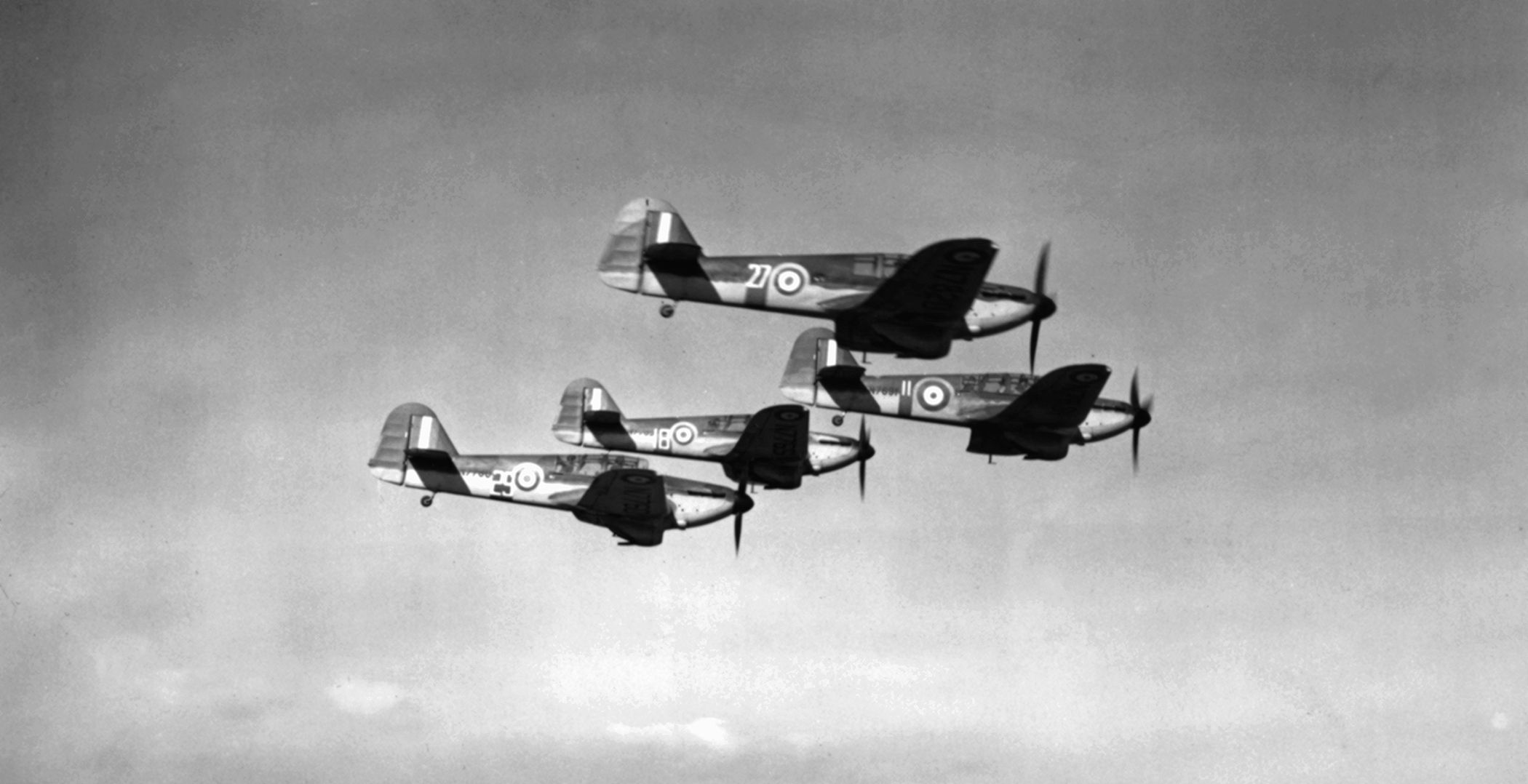 A flight of “American Eagle” pilots gets familiar with Hawker Hurricanes during aerial training at an RAF base.