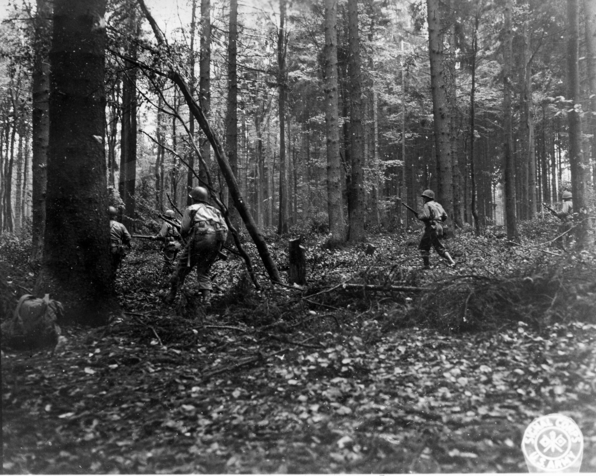 GI riflemen of the 110th Infantry advance through the Hürtgen Forest near Vossenack, Germany, in December 1944.