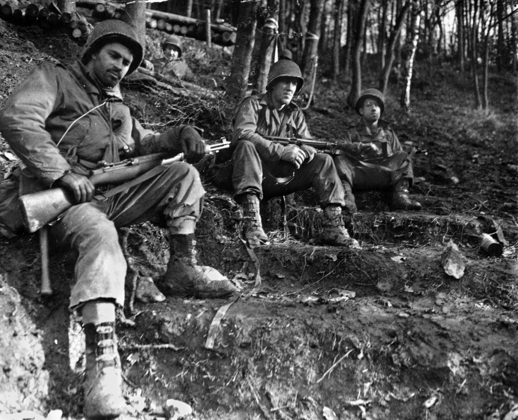 Weary from the rough travel through the Hürtgen Forest, men of the 4th Infantry Division take a brief but much-needed rest. 