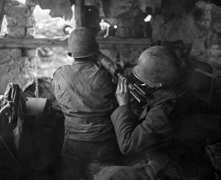 A 4th Division bazooka team  in an abandoned buidling in Grosshau awaits the arrival of German tanks.