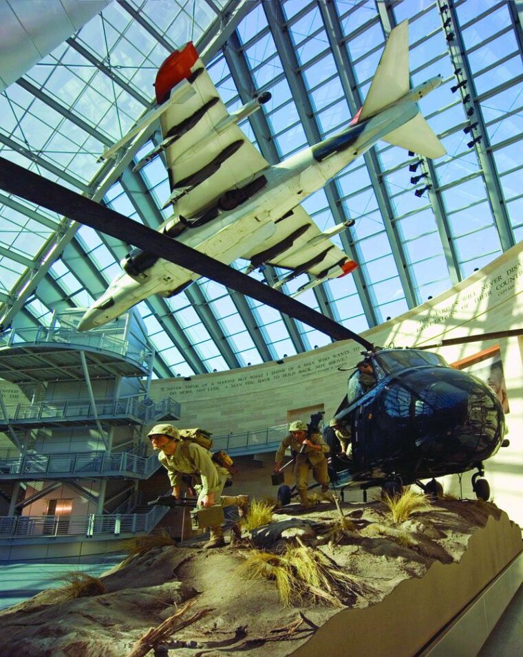 The central Leatherneck Gallery includes an AV-8B Harrier “jump jet” while a Sikorsky HRS-2 helicopter disembarks a machine-gun unit onto a Korean War position. 