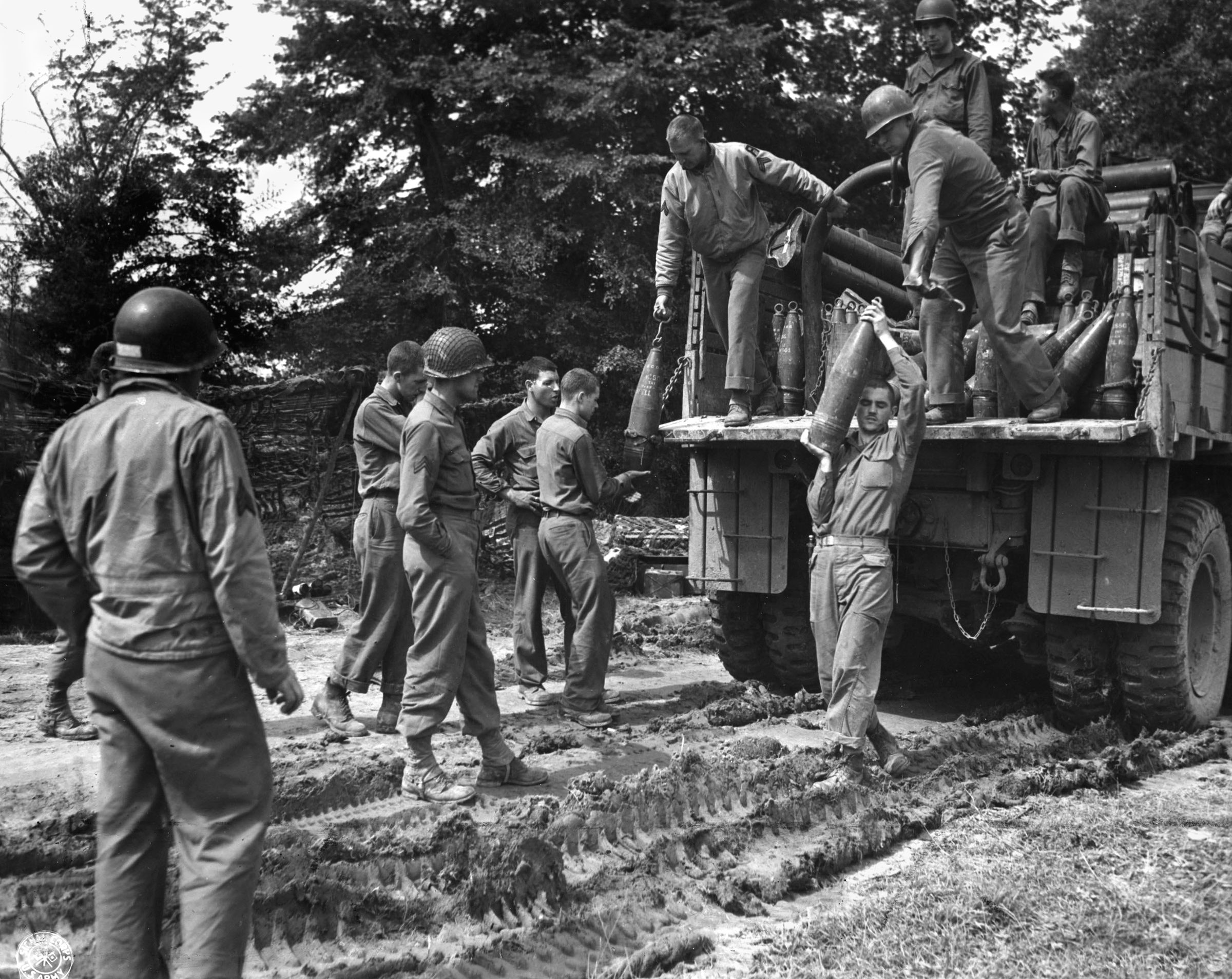 U.S. troops unload projectiles from a Red Ball truck to be used against the German front lines near St. Lo.