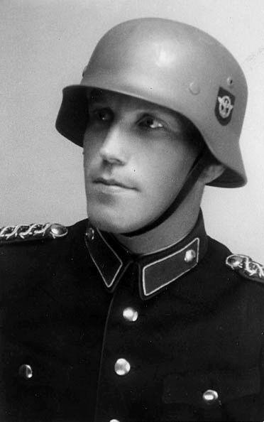 A German policeman wears the M1935 combat helmet.