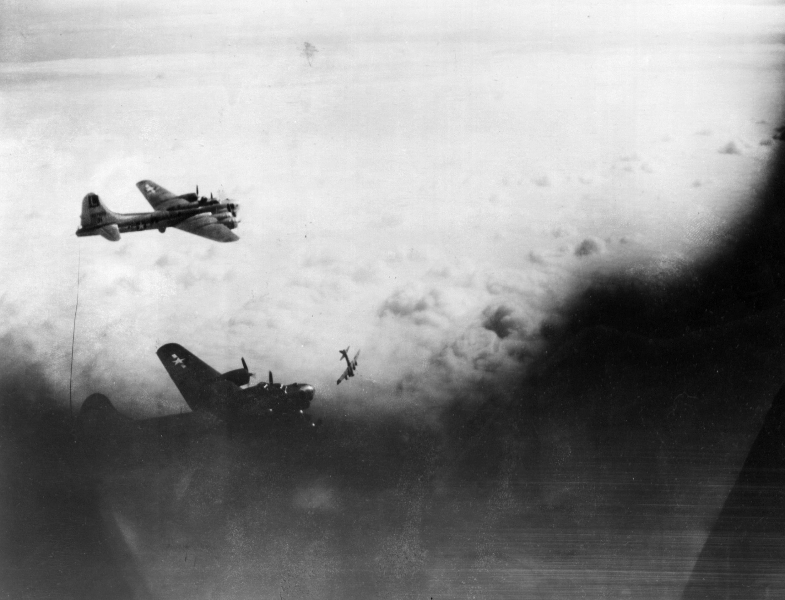 After the mid-air collision, Walthall’s B-17 began to plummet earthward in a backward spin similar to the attitude of the bomber in this photo at lower right. The stricken Flying Fortress quickly descended into a bank of clouds