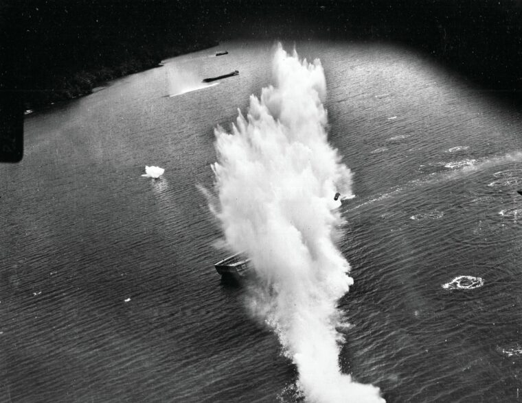 Caught in an attack by U.S. Army Air Forces bombers, a Japanese merchant ship takes hits off the coast of Dutch New Guinea during a June 1944 raid. Codebreaking work by cryptanalysts like Sergeant Joseph Richard helped detect enemy convoy movements.