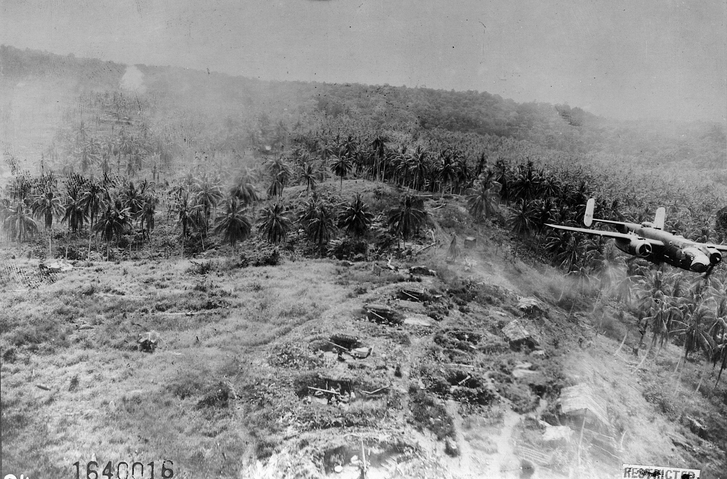 A B-25 crewman took this photo of a companion aircraft just above the New Guinea treetops—and an enemy antiaircraft emplacement—in January 1944.