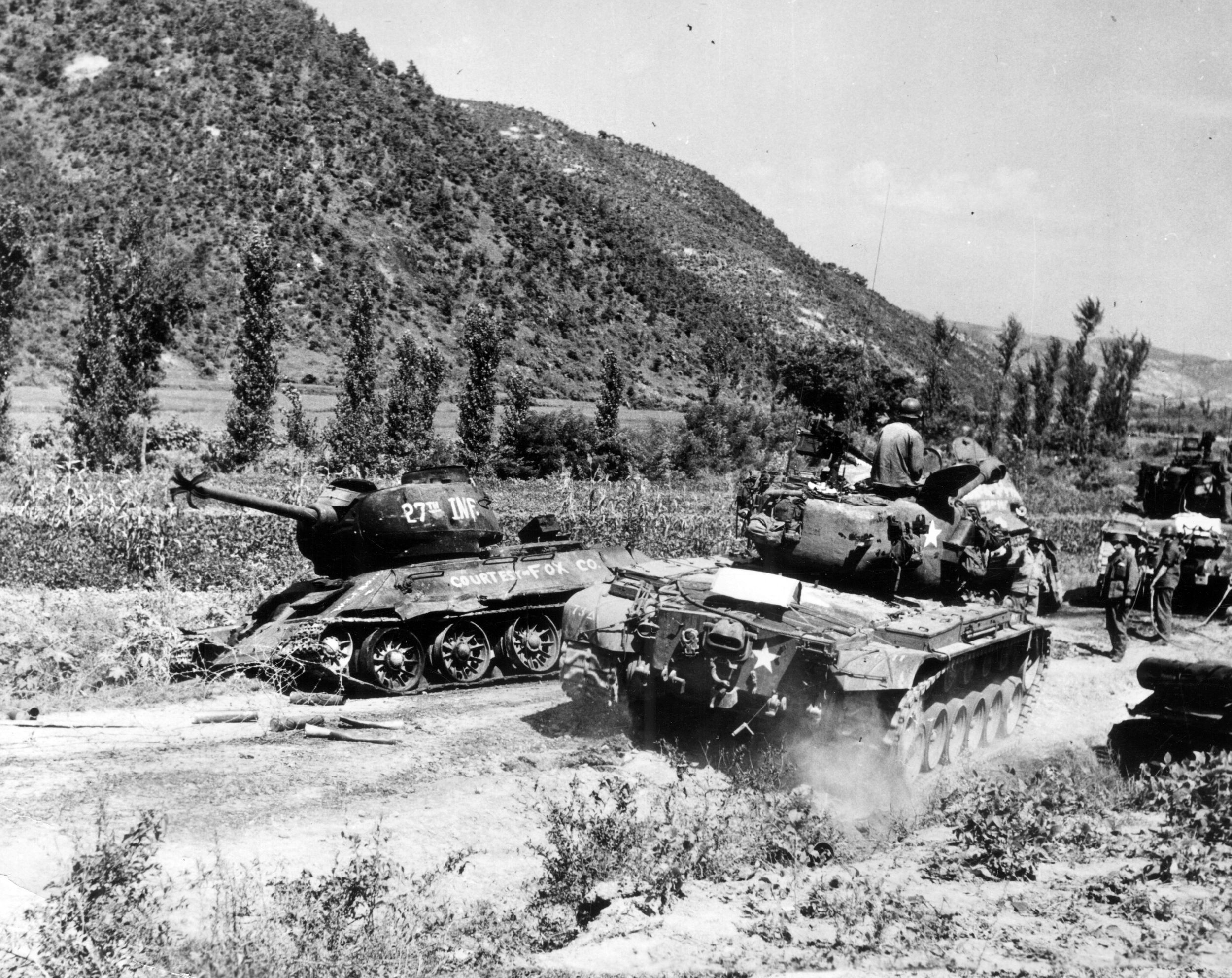An American M-26 Pershing tank of the 89th Medium Tank Battalion passes a Russian-made North Korean tank destroyed by Fox Company of the U.S. Army’s 27th Infantry Division during the retreat of North Korean forces in August 1950.