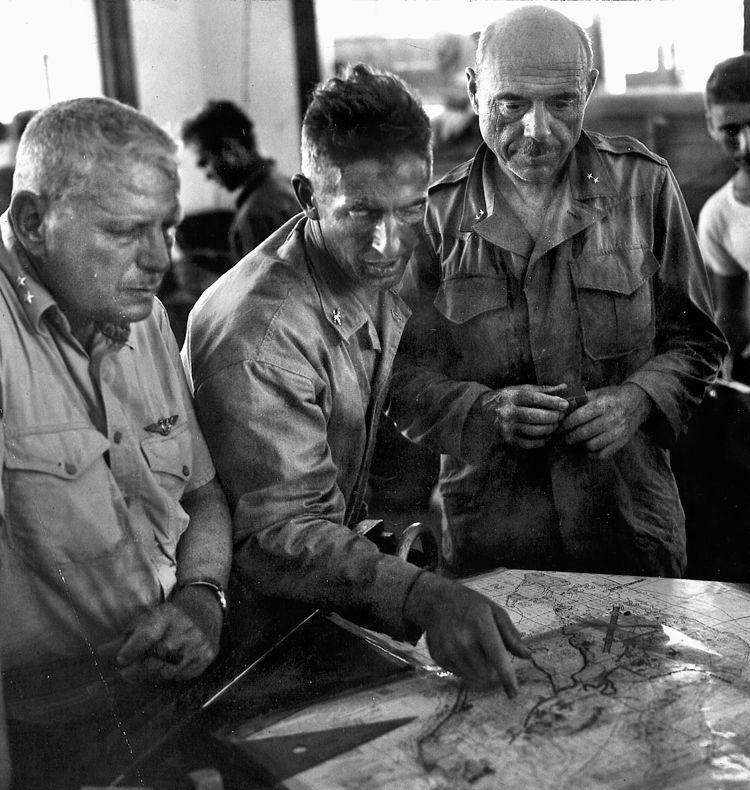 Maj. Gen. Roy S. Geiger (left), Col. “Bucky Harris (center), and Maj. Gen. William H. Rupertus (right), carefully study a map during operations planning for the Battle of Peleliu.