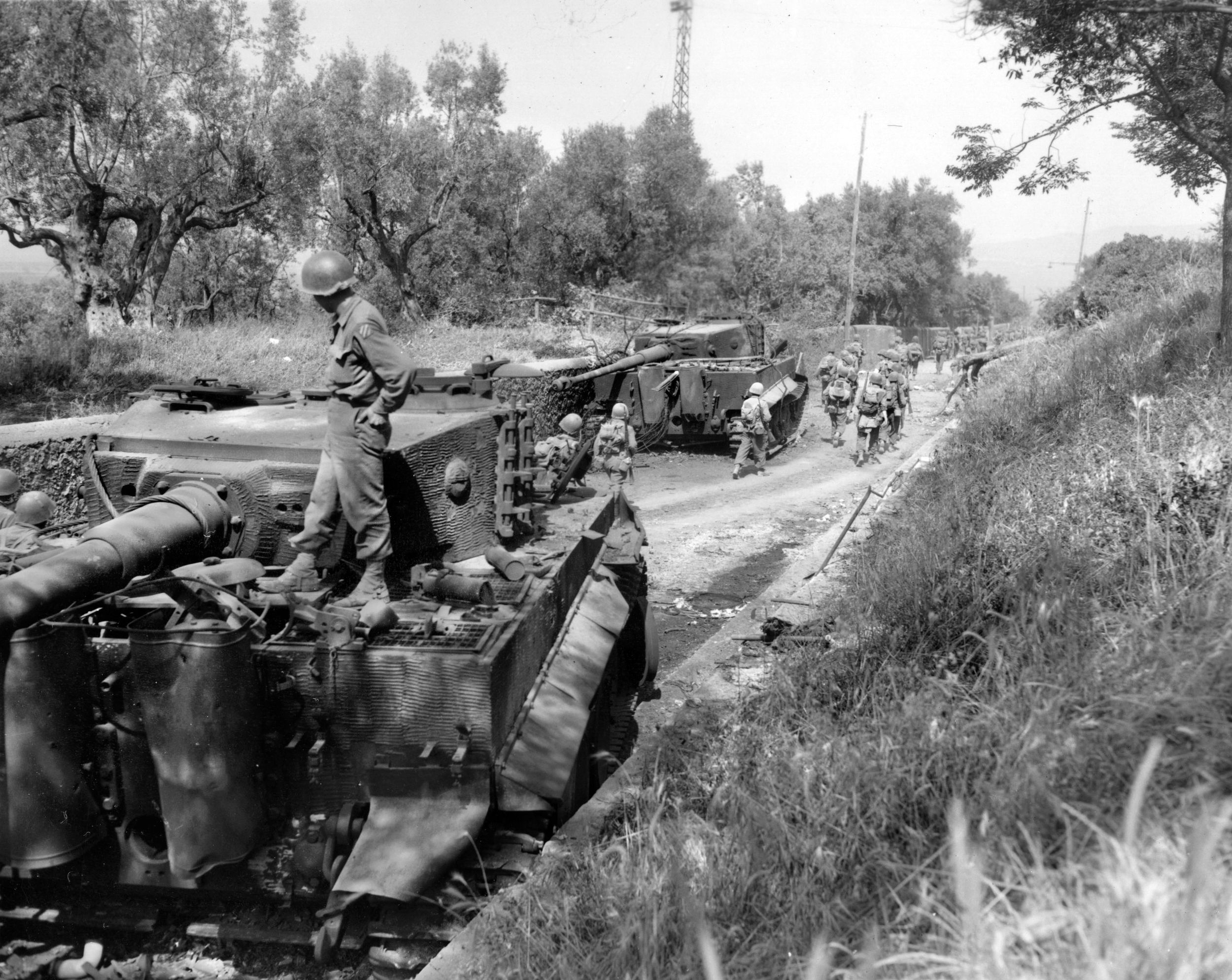 Third Division troops march past two knocked-out German Tiger tanks during the division’s advance on Cori, Italy, during the Allies’ breakout from the Anzio beachhead, May 1944.